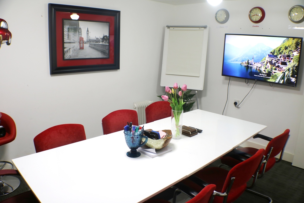 Modern conference room with white table and red chairs, perfect for meetings near Liverpool St.