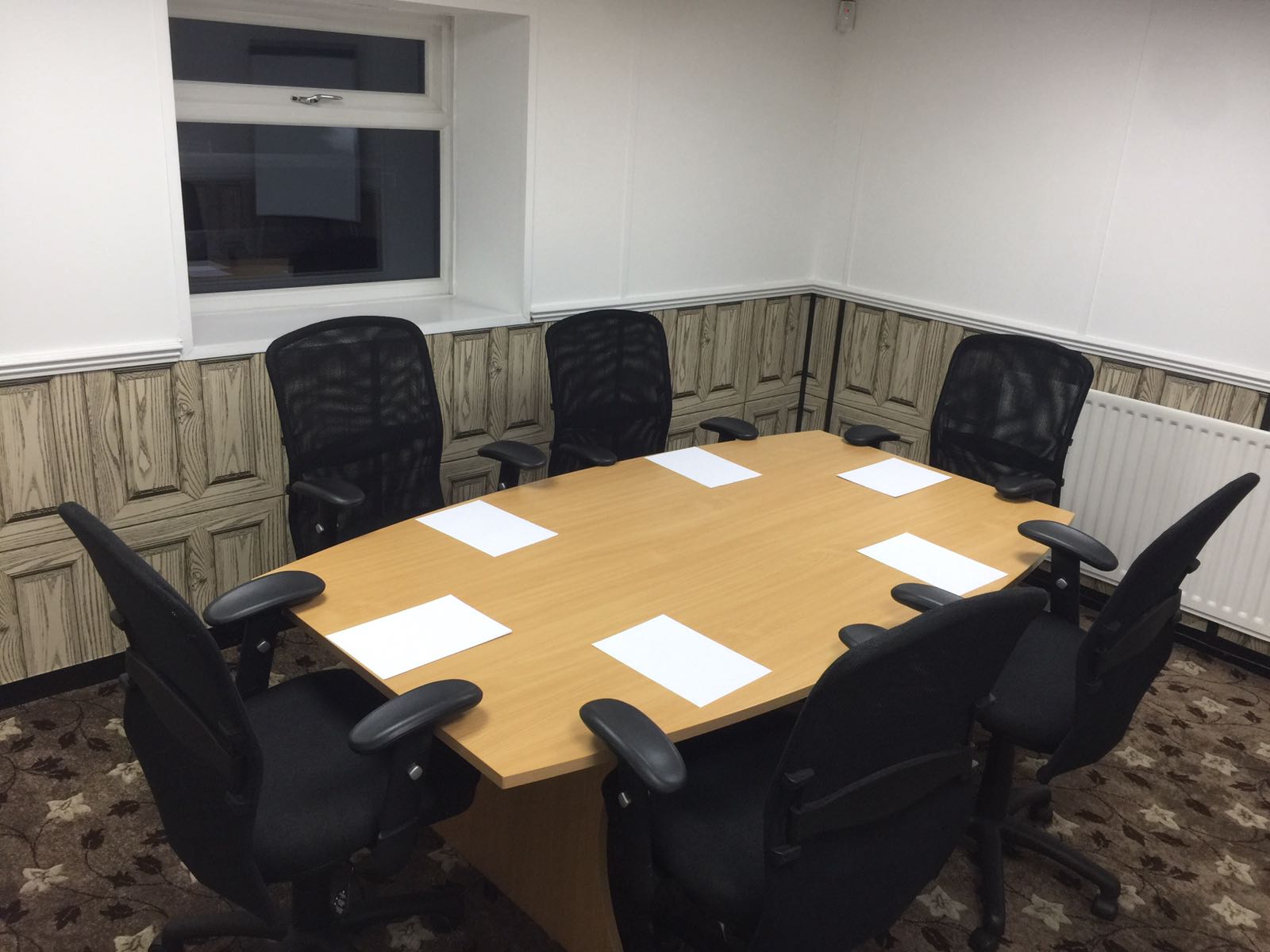 Meeting room with round table and ergonomic chairs for collaborative discussions.