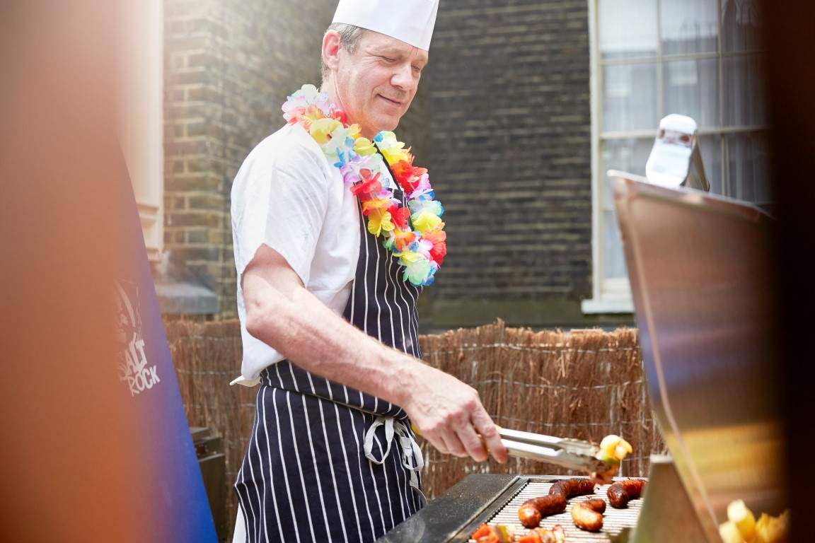 Chef grilling outdoors at The Beach Bar, perfect for summer gatherings and team-building.