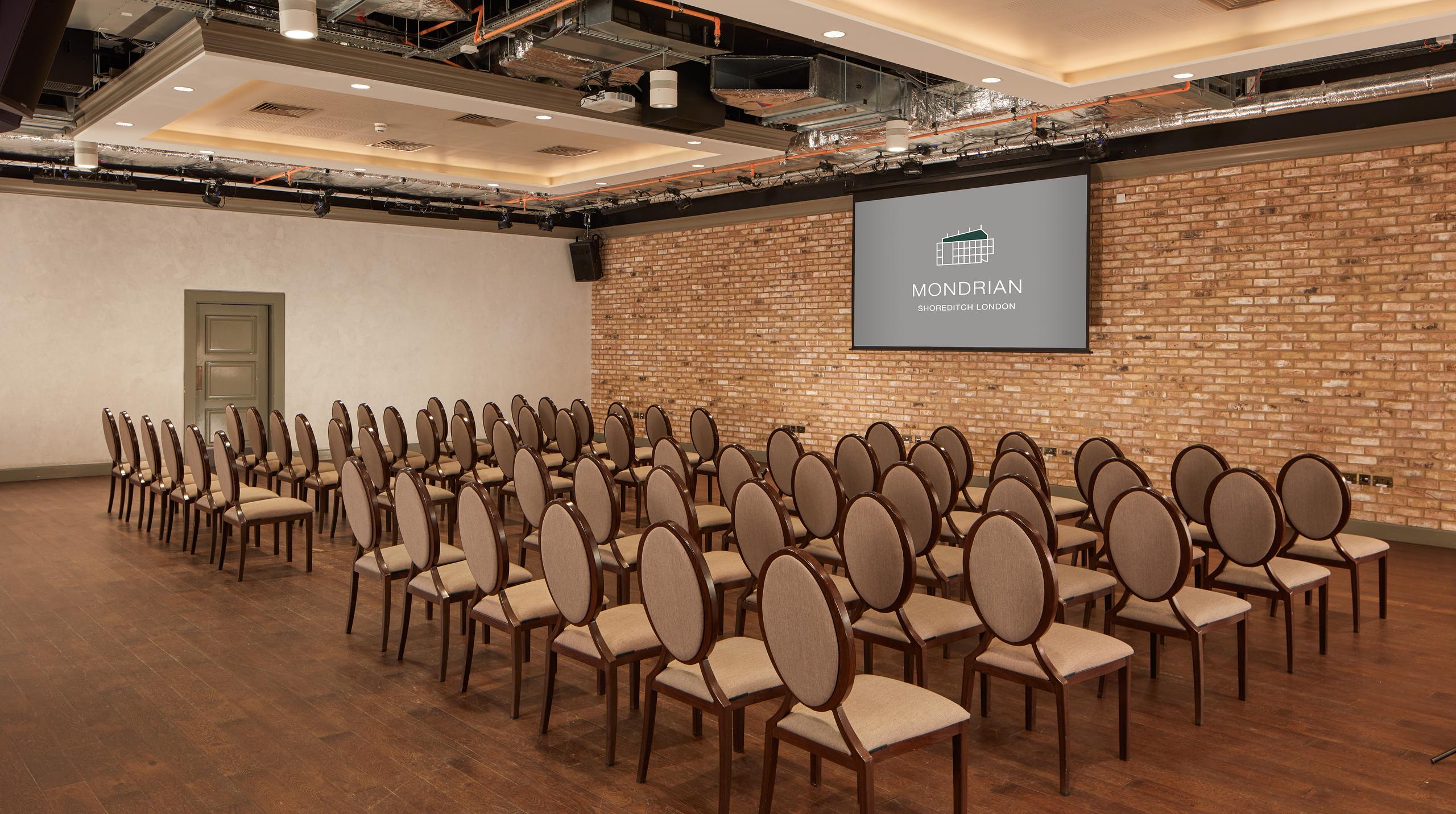 The Ballroom at Virgin Hotels London, elegant meeting space with modern design and brick accents.