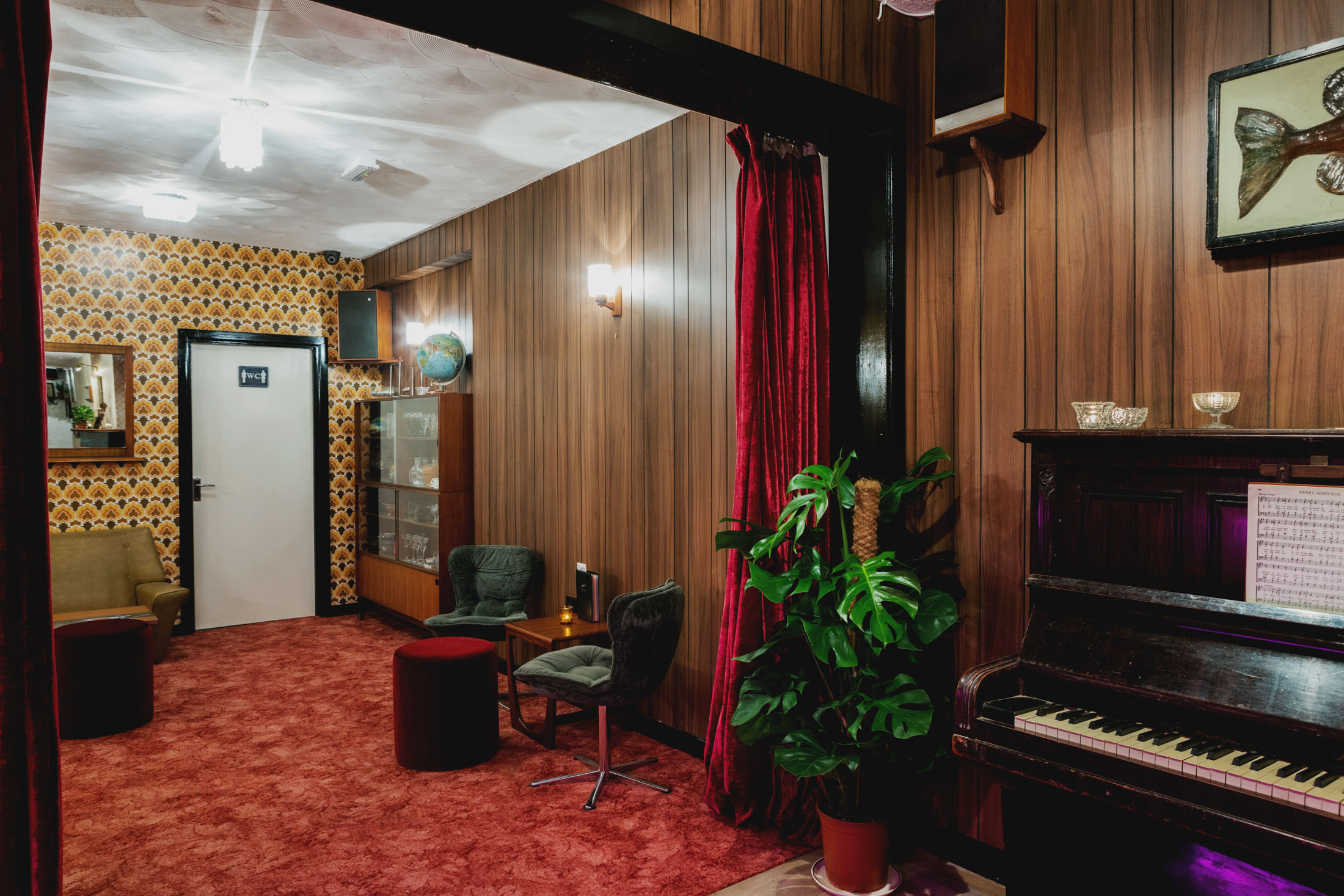 Retro basement bar with piano, perfect for creative meetings and events.