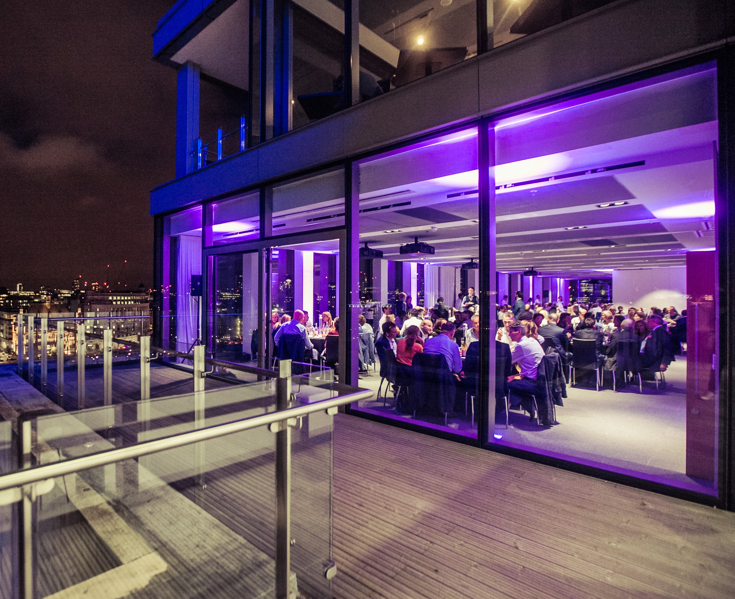 Sophisticated evening gala at Sea Containers Events with city views and elegant purple lighting.