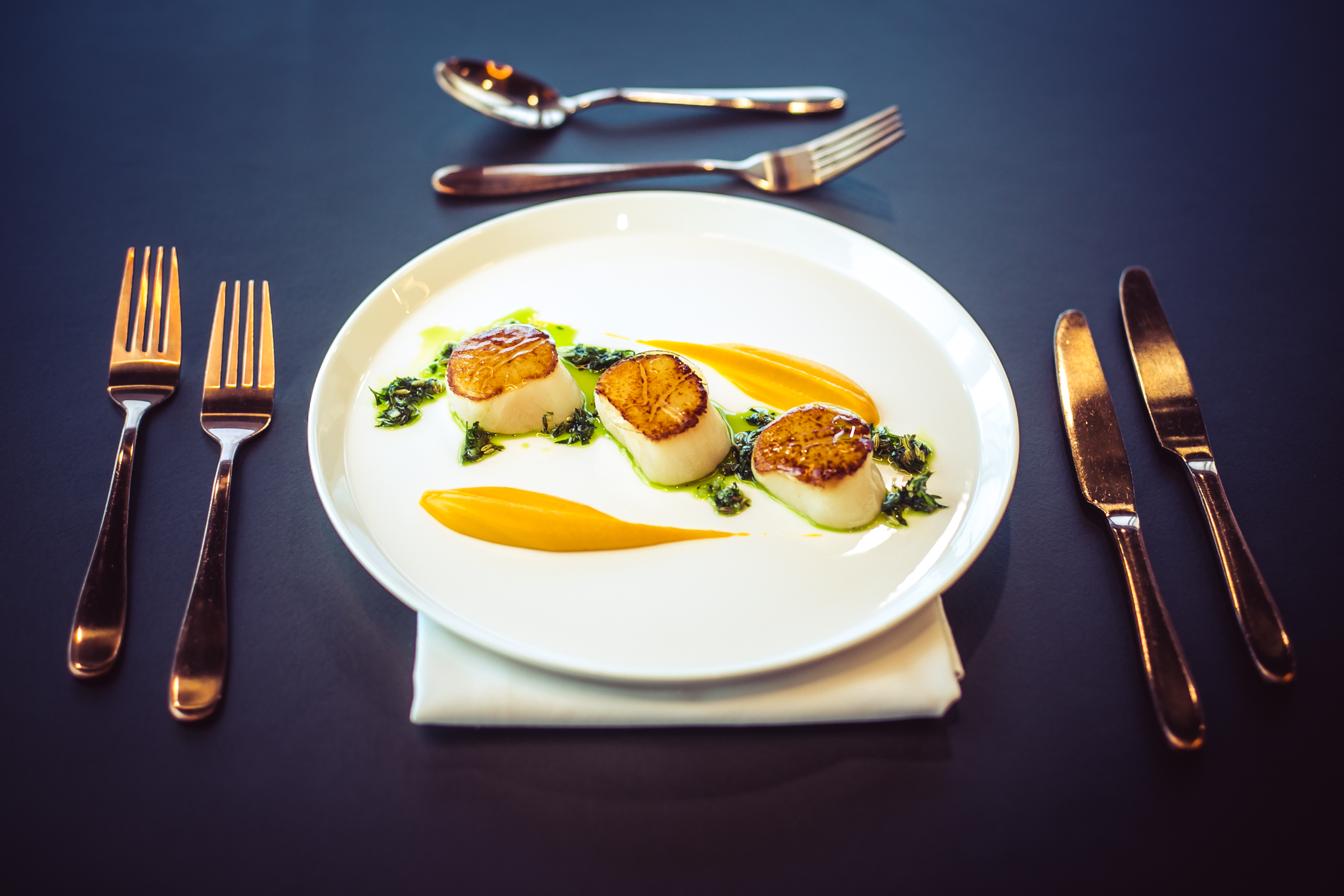Gourmet seared scallops dish at The Wren, perfect for upscale events and fine dining.