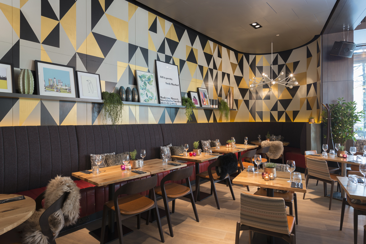 Modern restaurant venue with geometric wall, ideal for corporate events and gatherings.