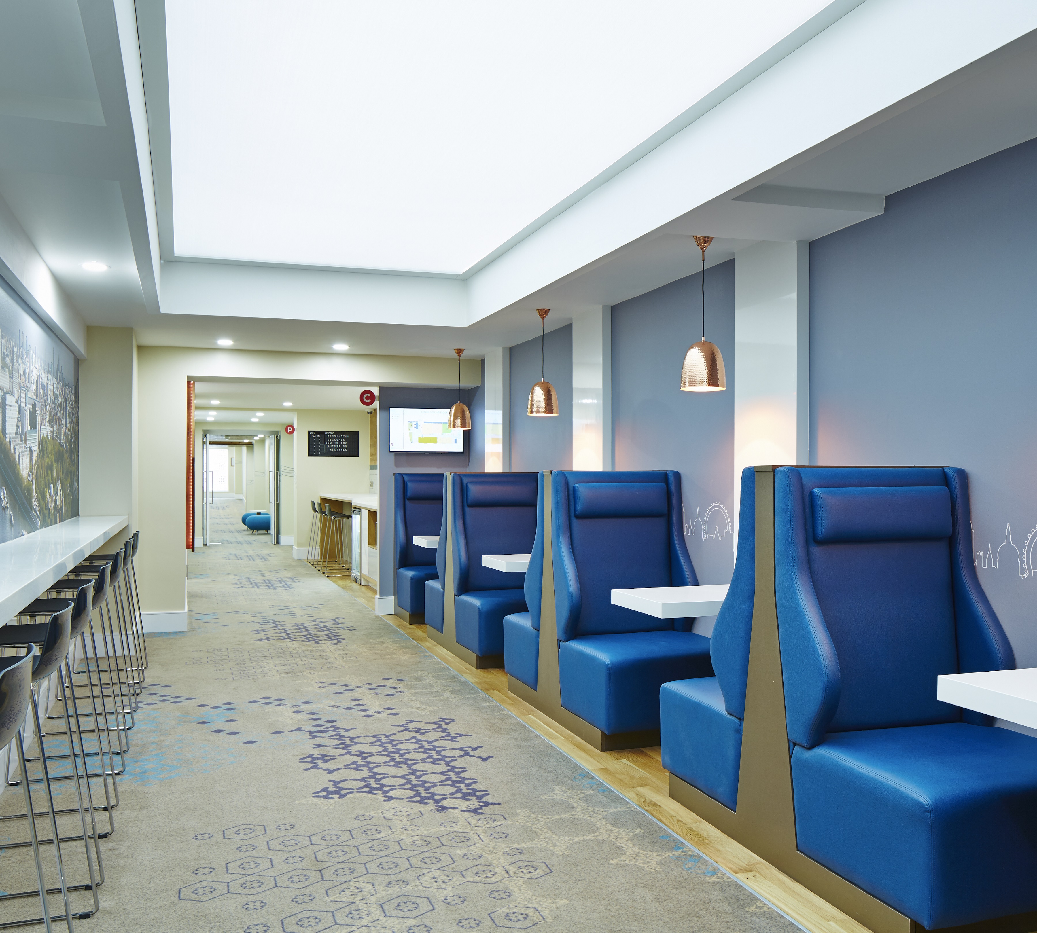 Modern meeting corridor with blue booths at London Marriott Hotel Kensington.