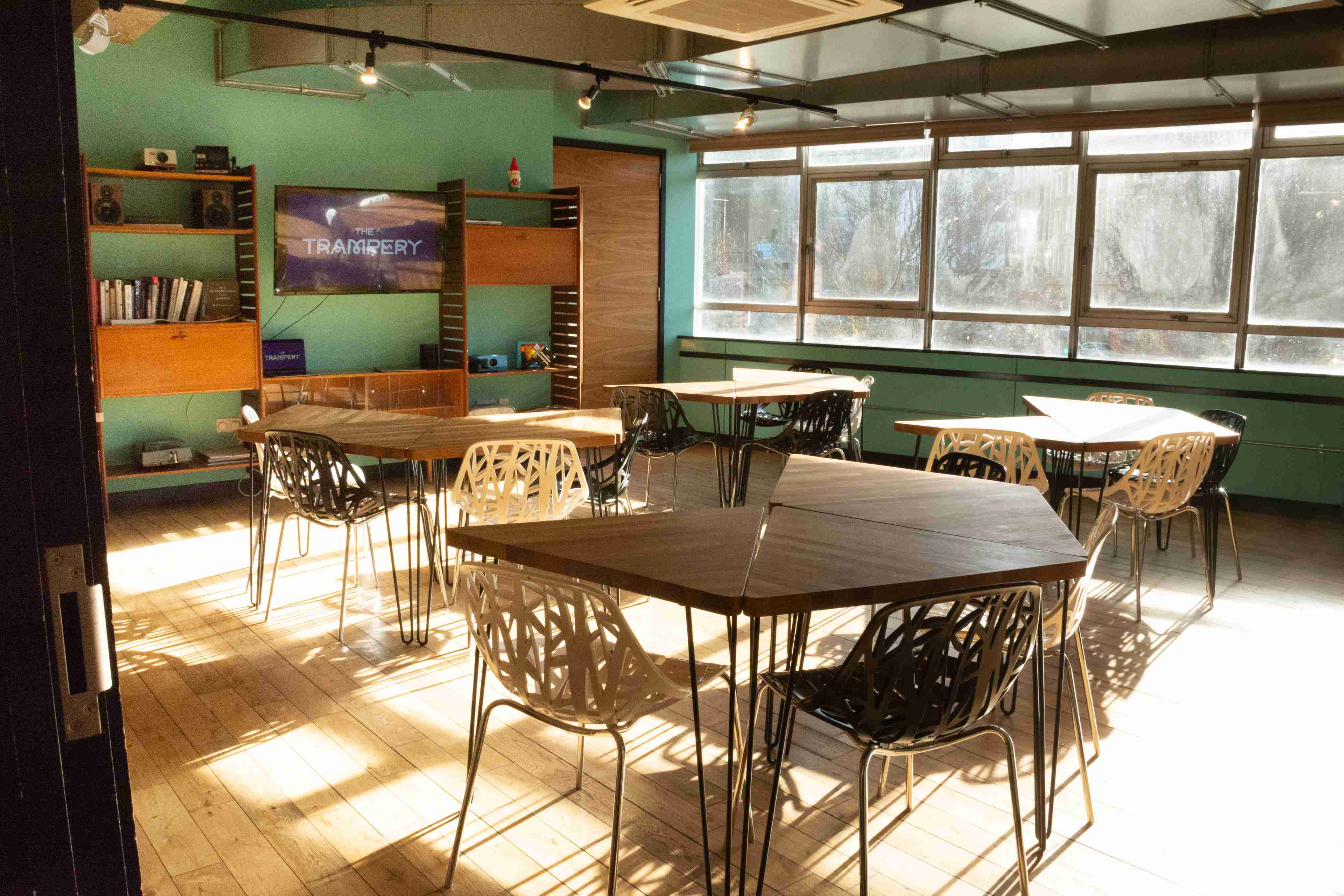 Modern meeting space with hexagonal tables, ideal for workshops and collaboration.