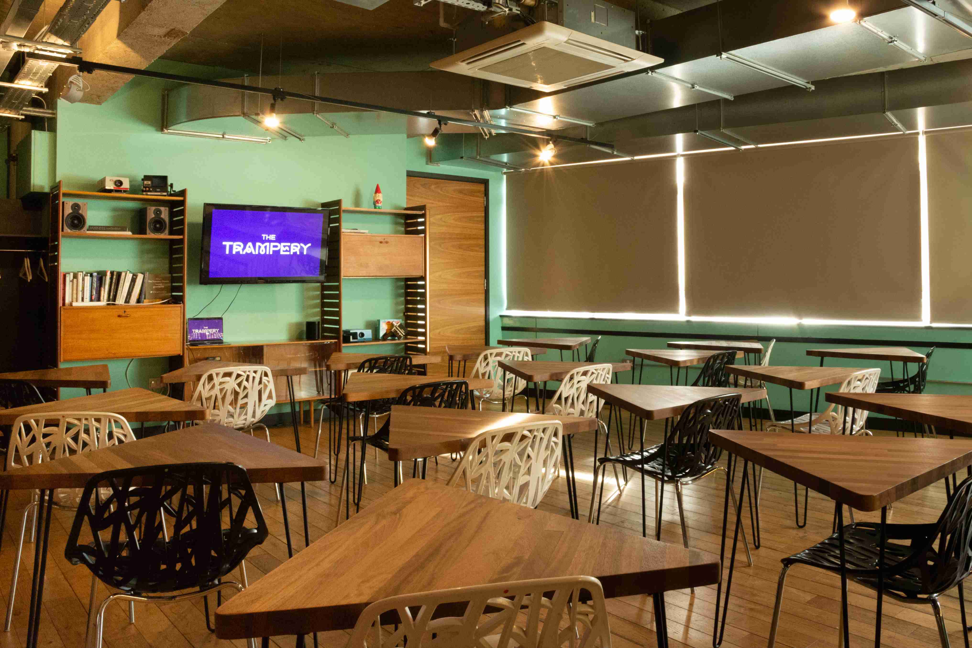 Modern meeting space with triangular tables for workshops and brainstorming sessions.