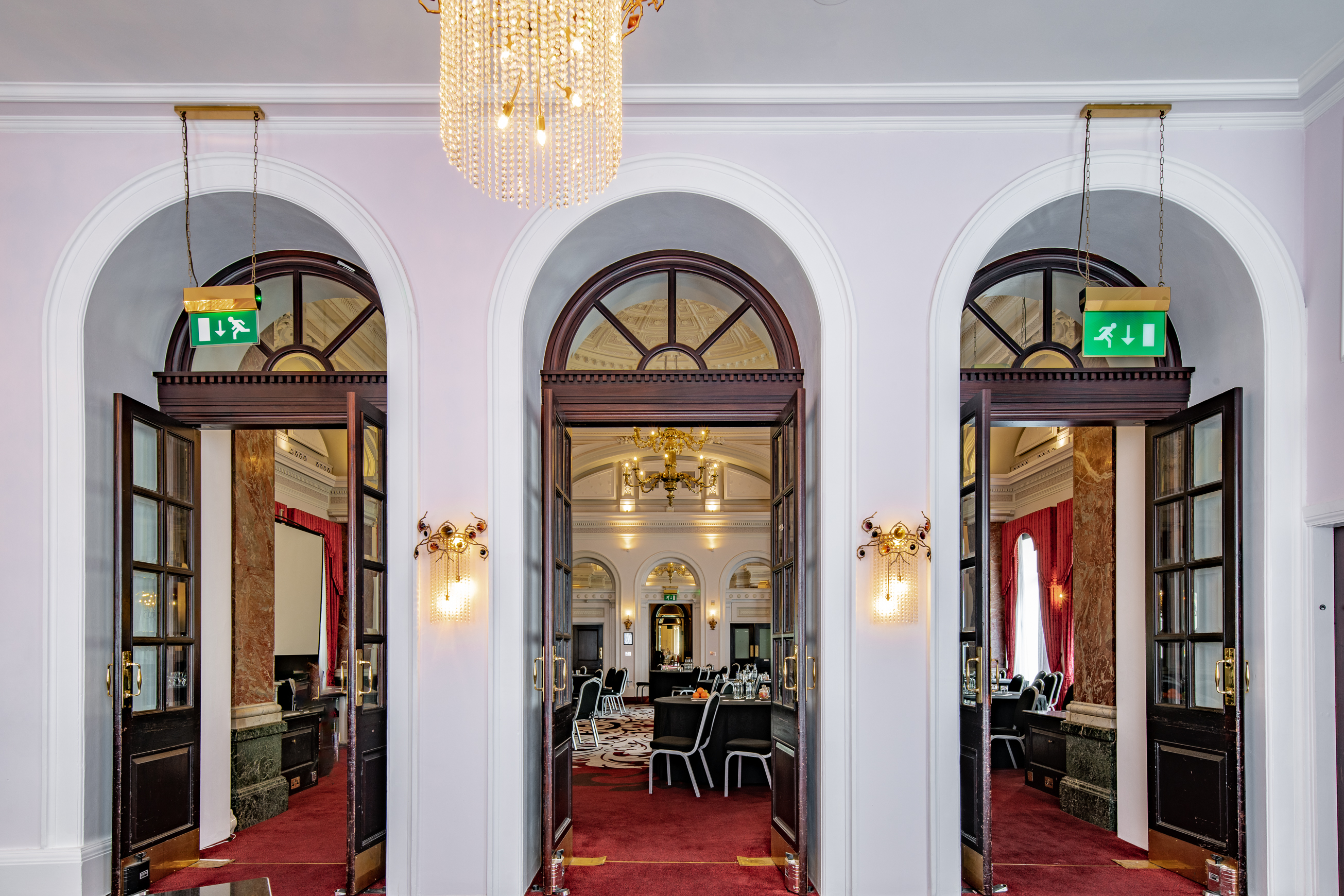 Elegant ballroom with arched doorways, perfect for upscale events and conferences.