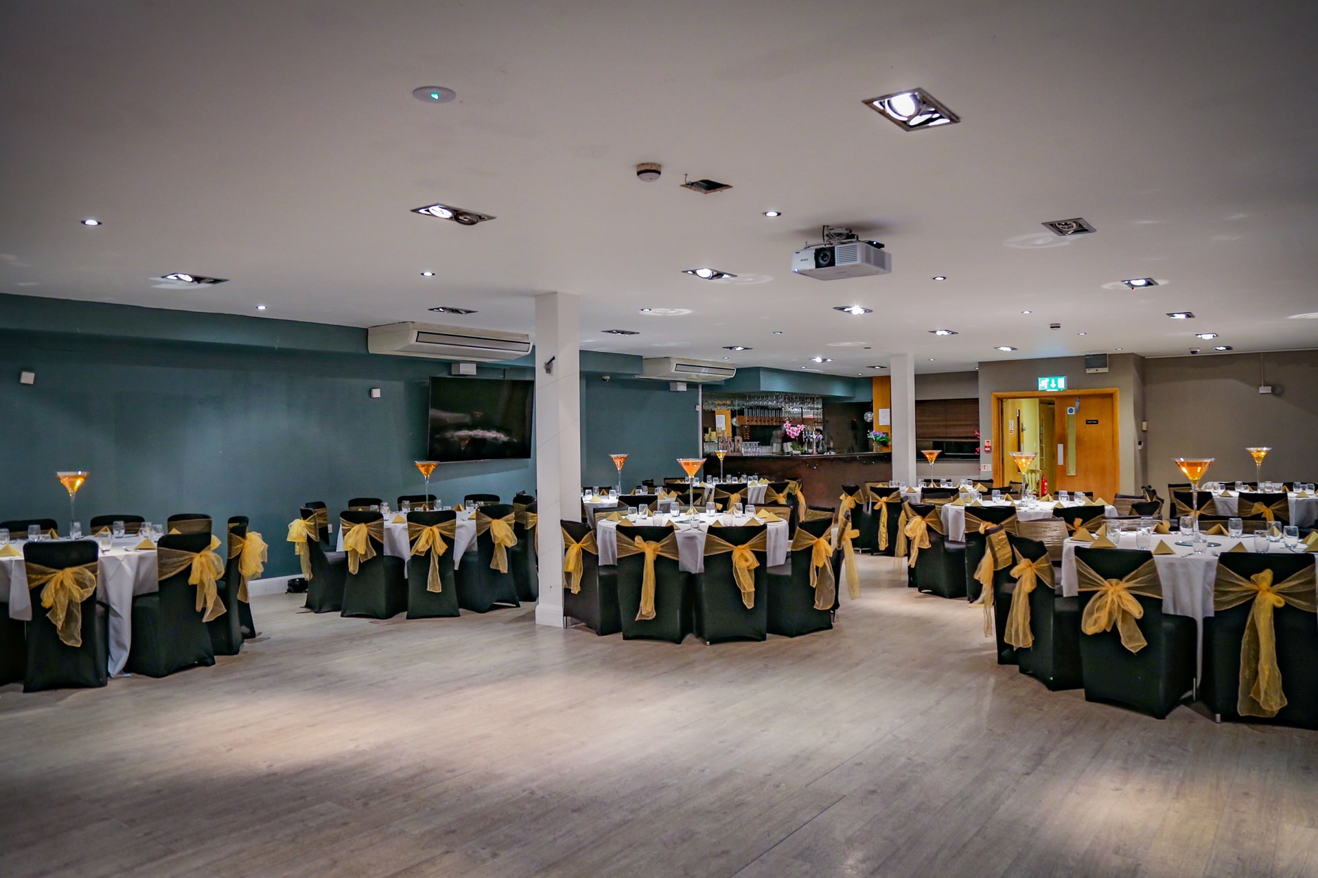 Elegant Mehfil Banquet setup with green and white linens for weddings and corporate events.