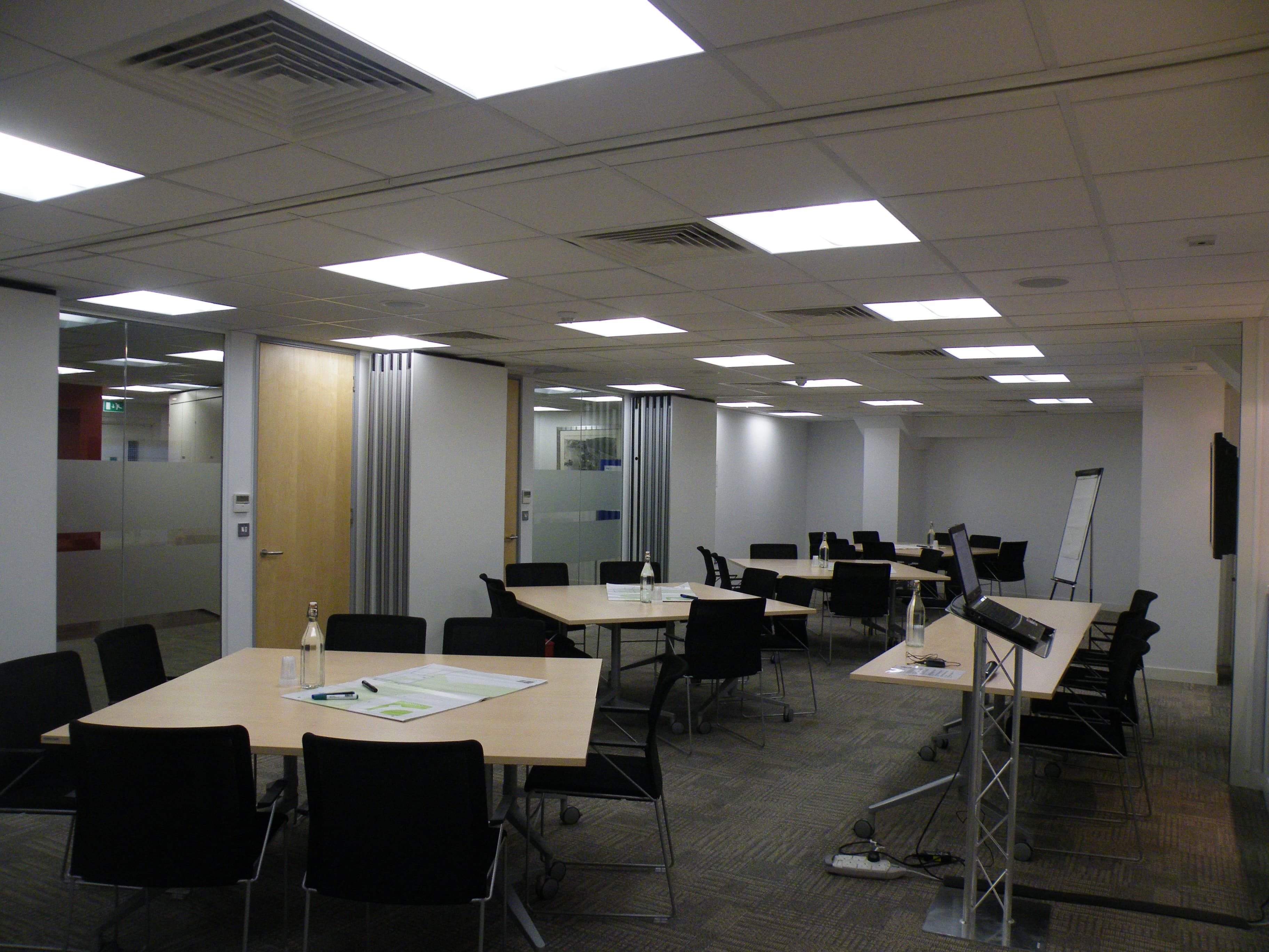 Flexible workshop meeting room with movable tables & whiteboards.
