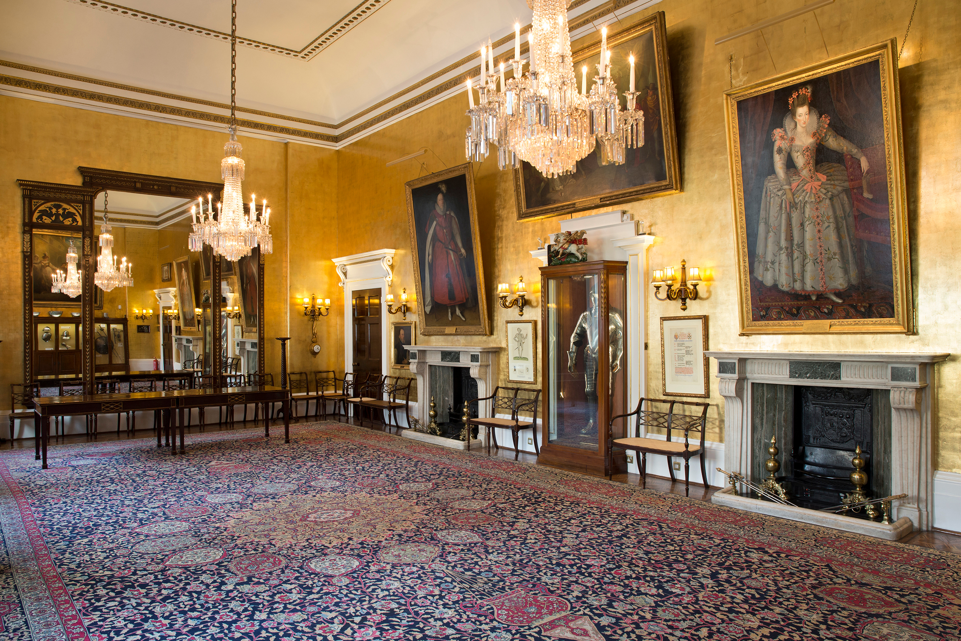 Elegant event space in Armourers' Hall with golden walls, ideal for formal gatherings.