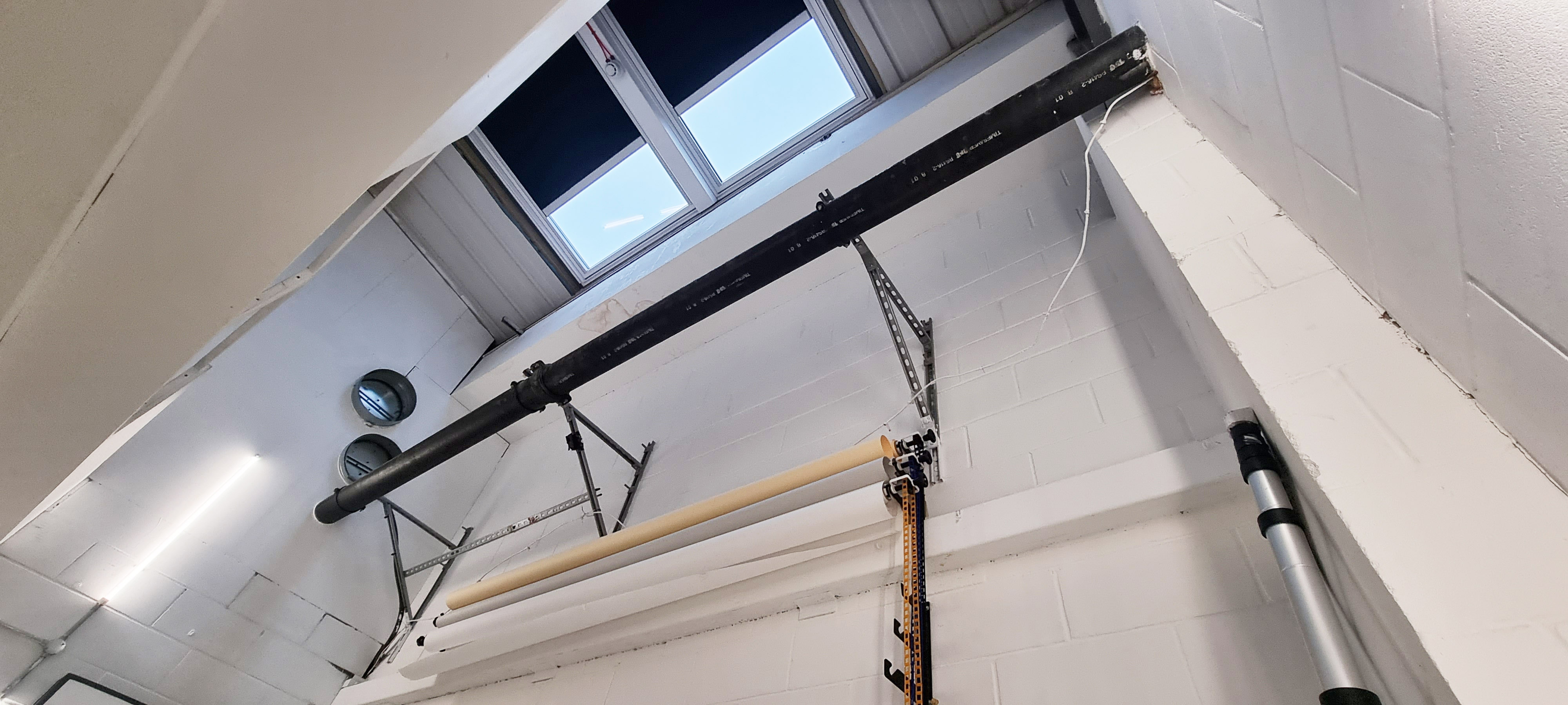 Versatile event space with industrial ceiling setup at Indra Studios for workshops and presentations.