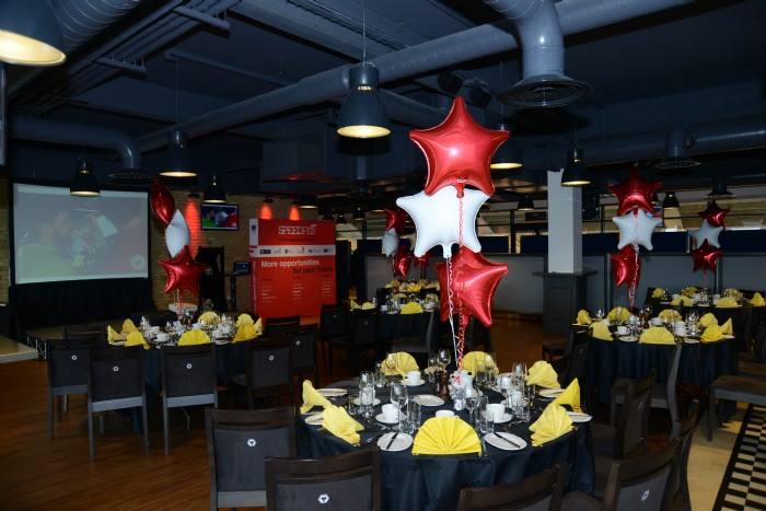 Elegant event space at Molineux Stadium with black tablecloths and festive balloons.