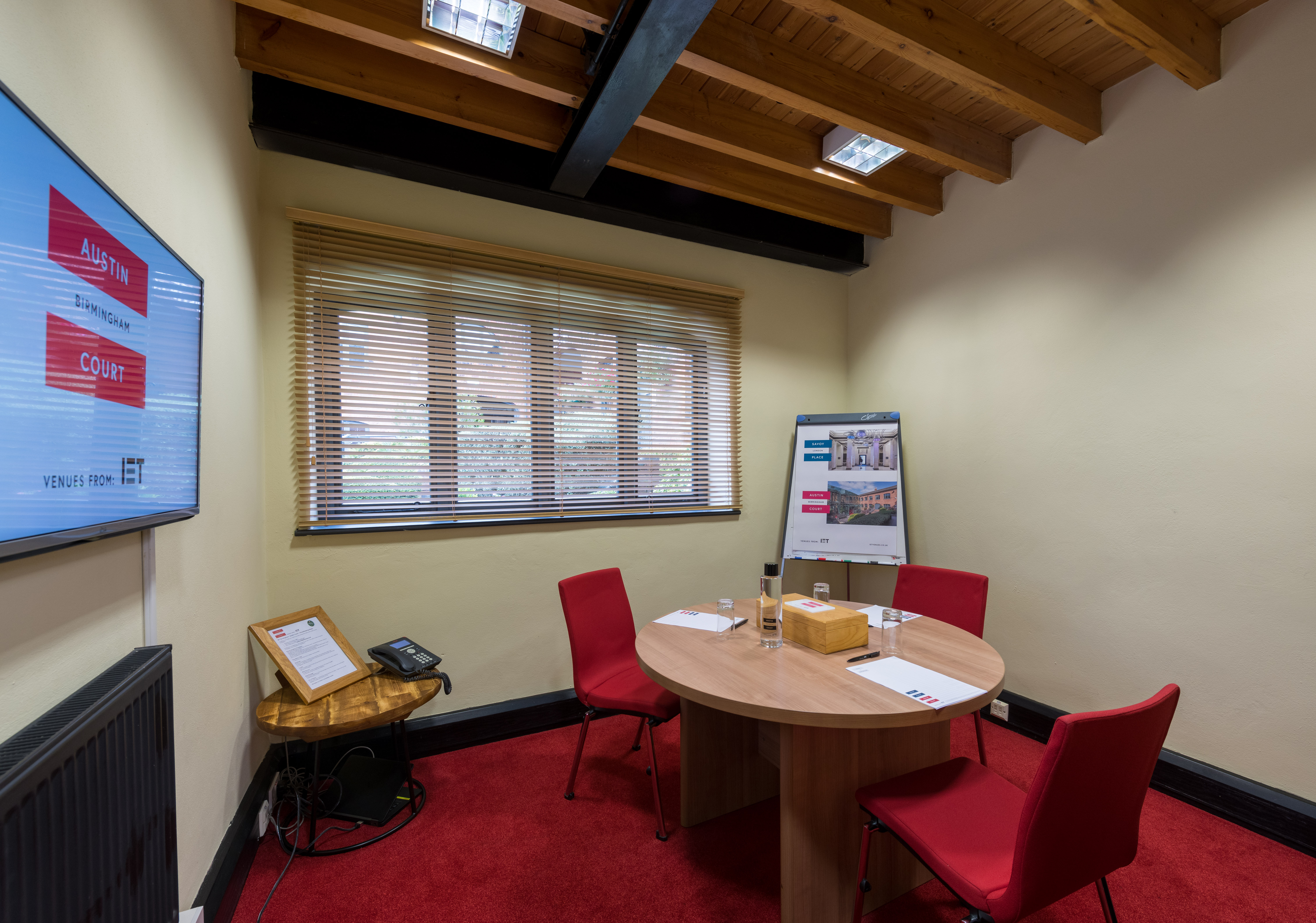 Edison Room at IET Birmingham: round table, red chairs for meetings and brainstorming.