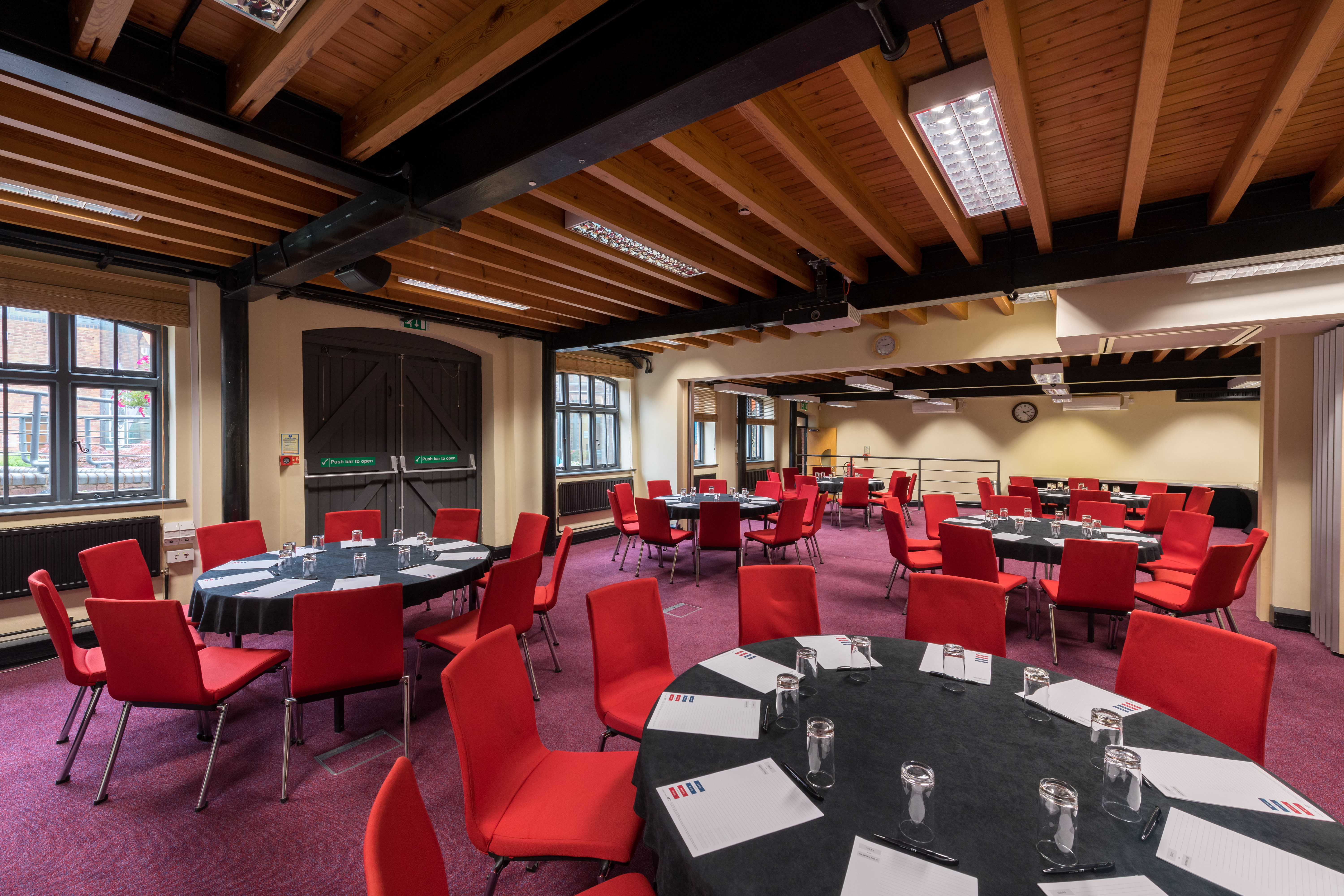Faraday Room at IET Birmingham: round tables, red chairs, ideal for meetings and banquets.