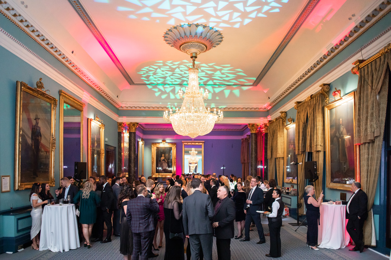Vibrant networking event in Nash Room, 116 Pall Mall with elegant chandelier.