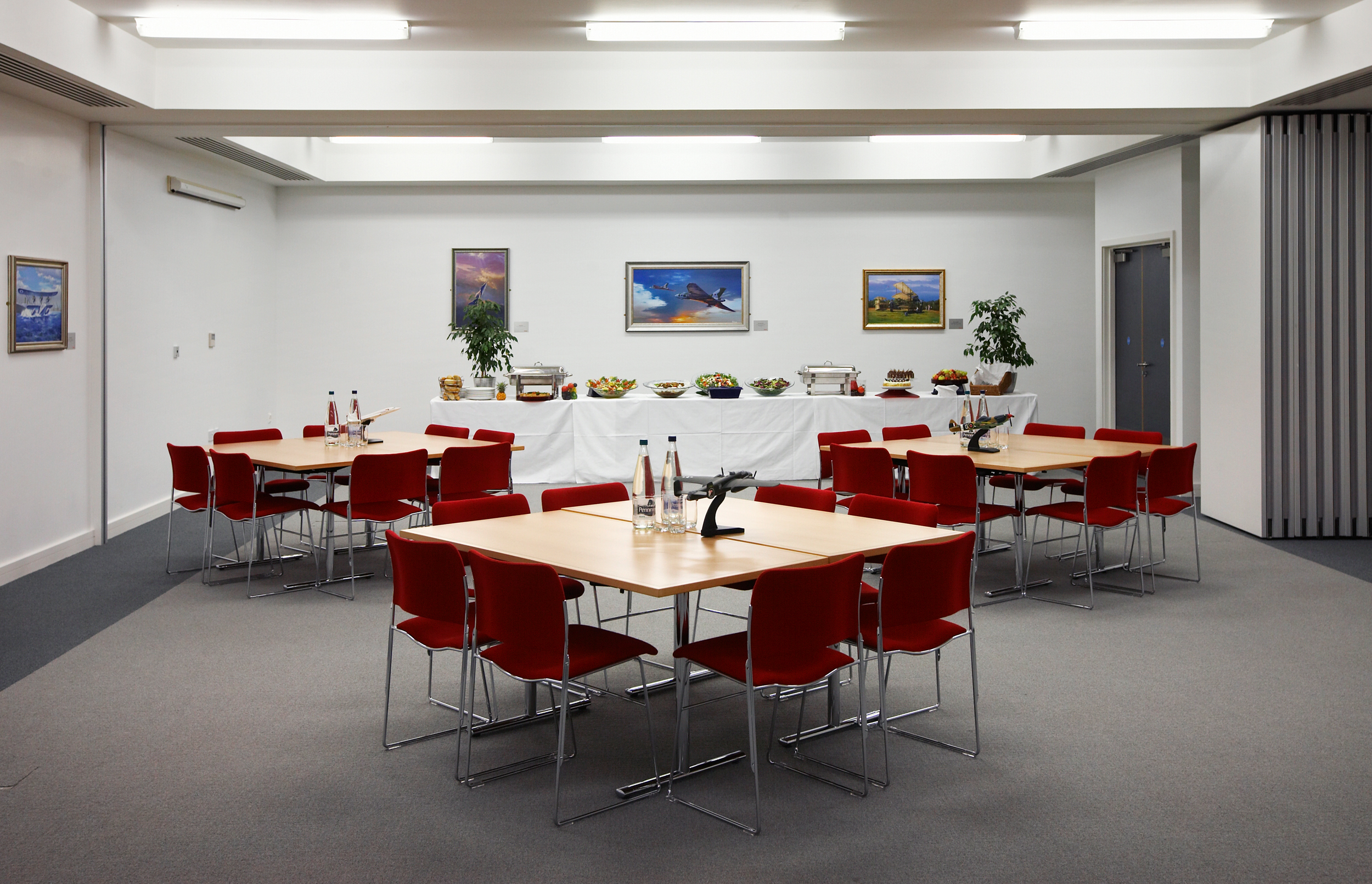 Concorde Suite at IWM Duxford: round tables, red chairs for workshops and networking events.