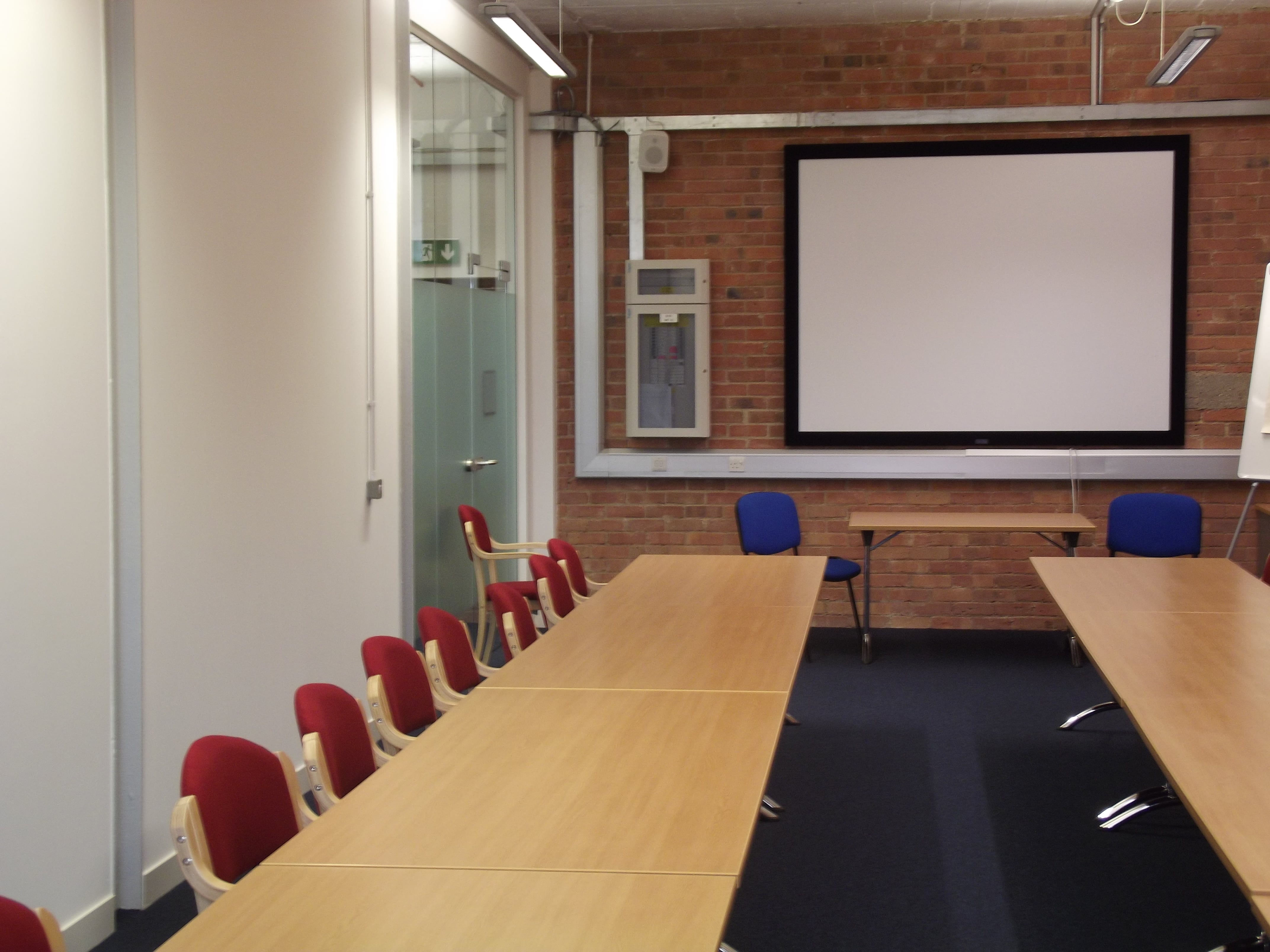 Meeting room 1 in Studio 22 with wooden table, ideal for meetings and brainstorming.