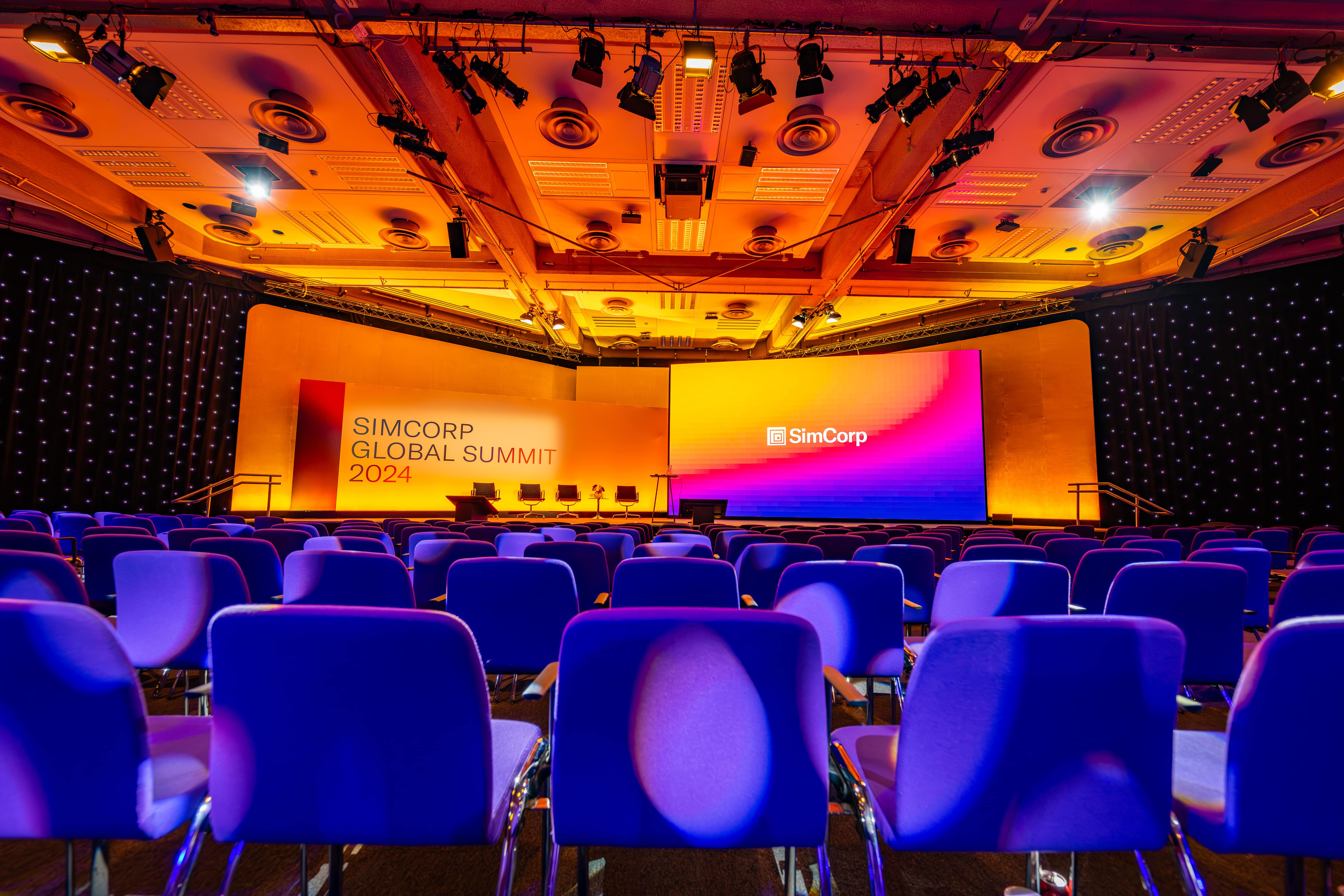 Conference setup at SimCorp Global Summit 2023 with vibrant branding and seating.