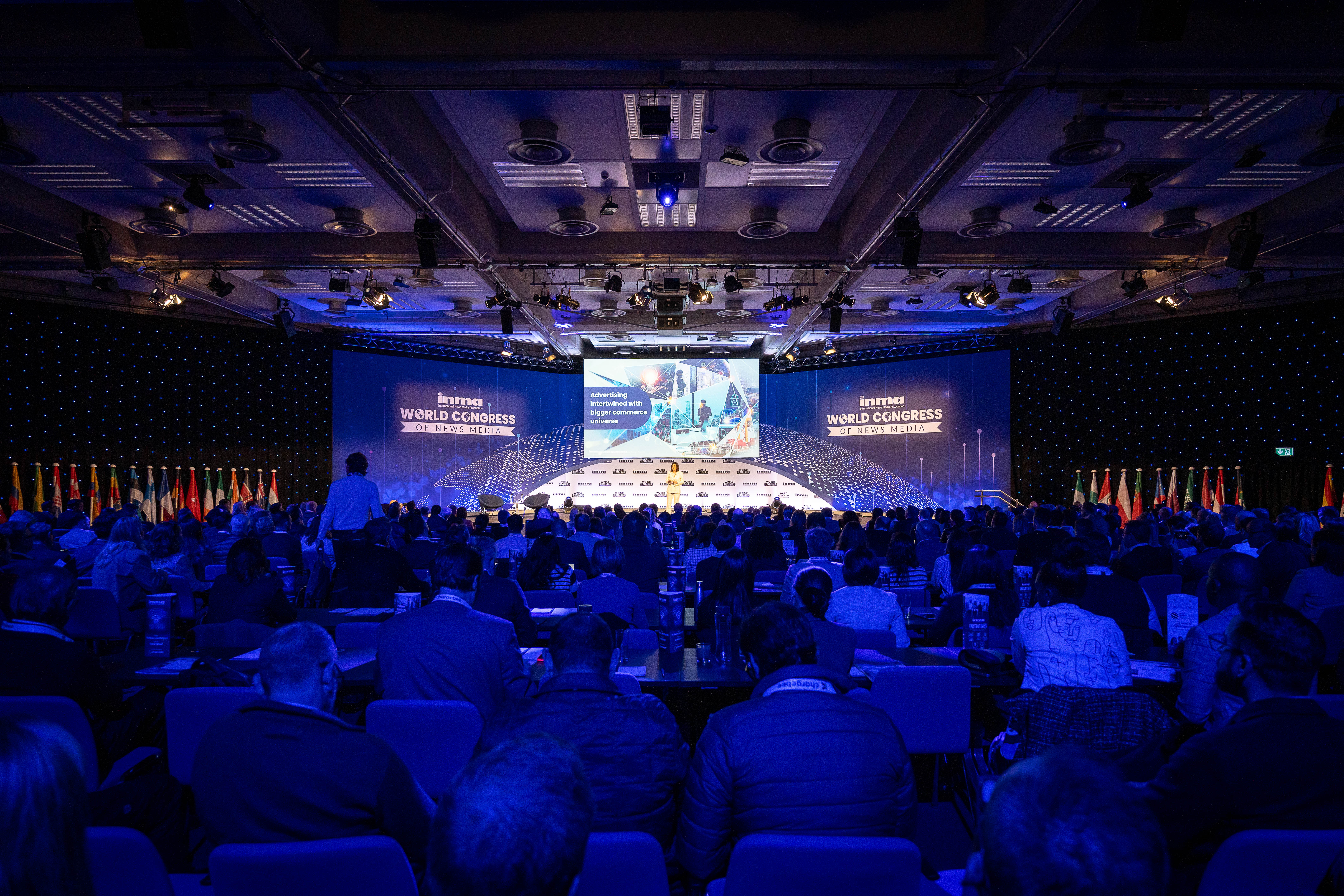 Conference setup at QEII Centre with engaged audience and prominent stage screen.
