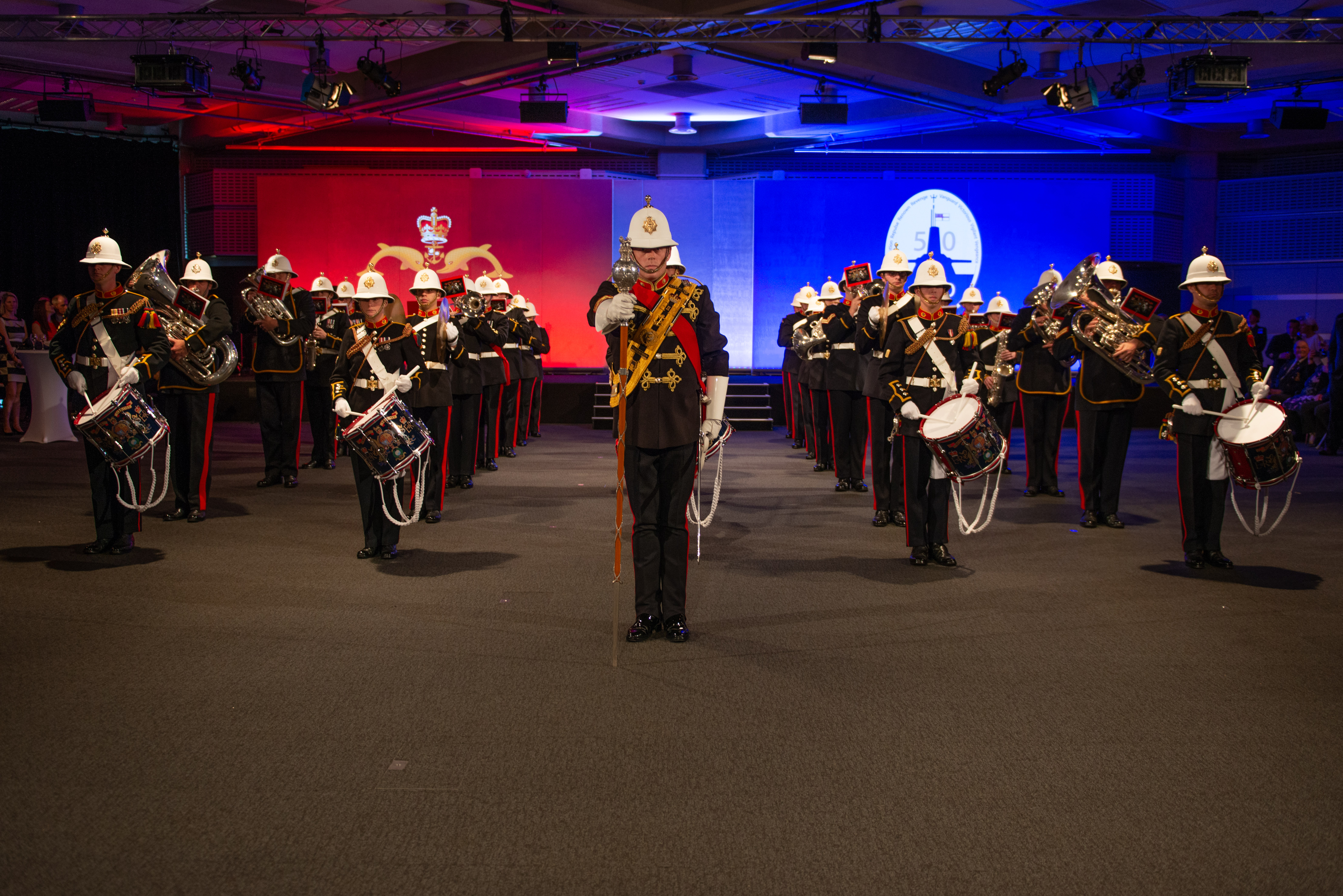 Military band performance at QEII Centre with striking backdrop for formal events.