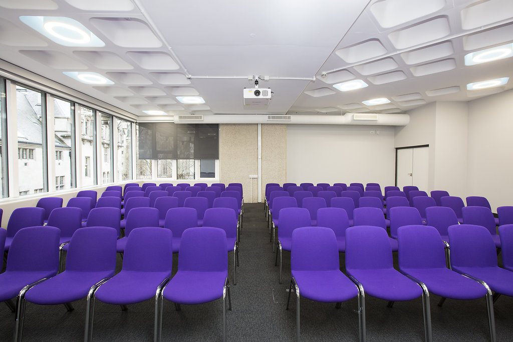 Albert in QEII Centre with purple chairs, perfect for workshops and presentations.