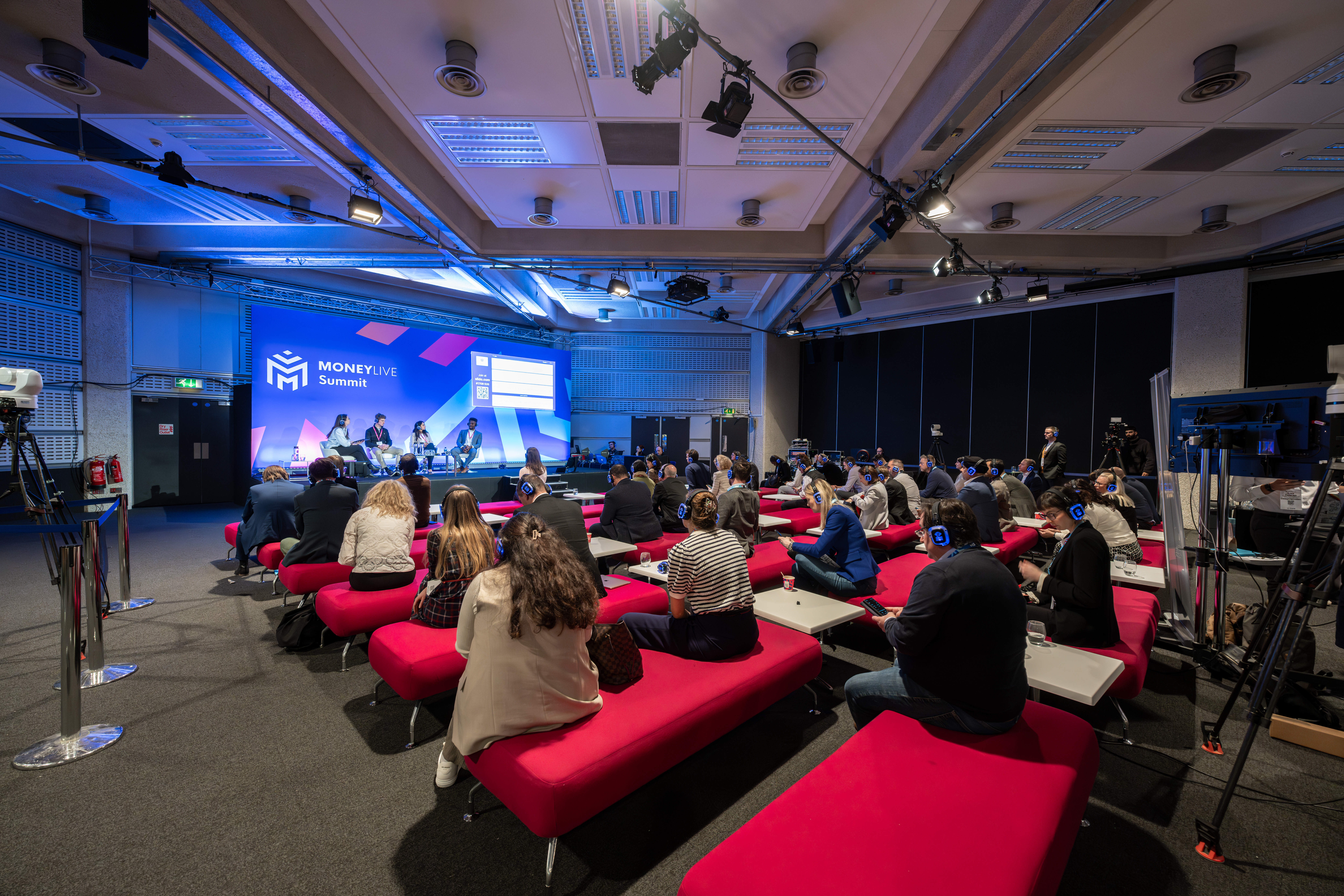 Third Floor event space with red sofas for panel discussions and professional lighting.
