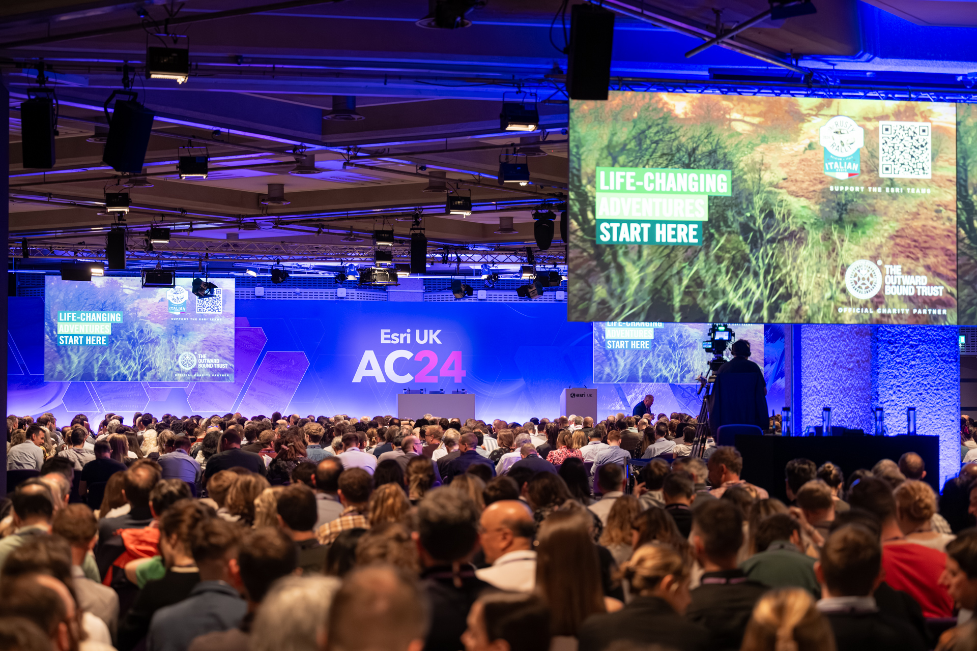 Third Floor conference at QEII Centre with engaging audience and prominent screens.