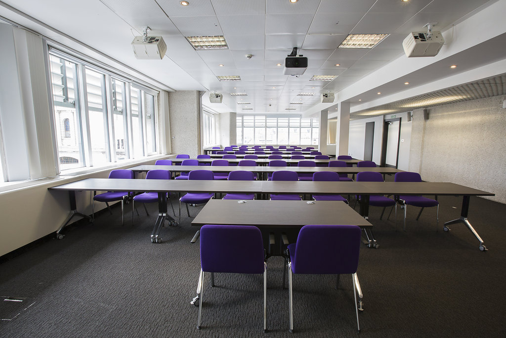 Versatile meeting space in QEII Centre with purple chairs for workshops and training.
