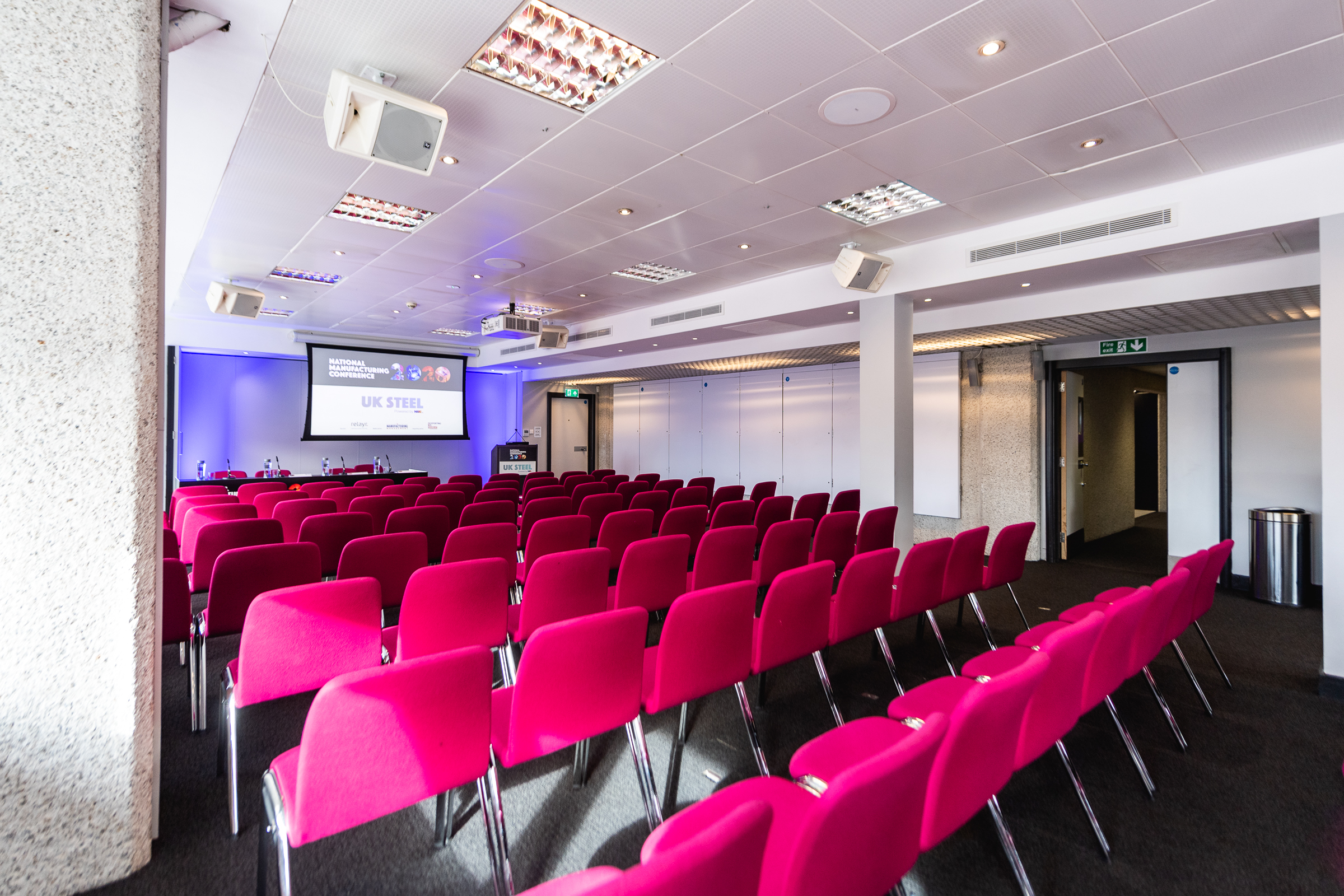 Modern conference room with pink chairs at QEII Centre for engaging events.