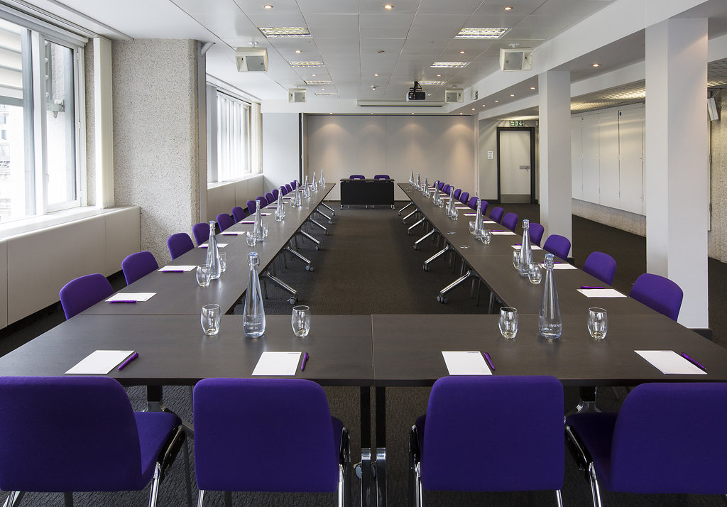 Abbey in QEII Centre meeting room with purple chairs, ideal for professional events.