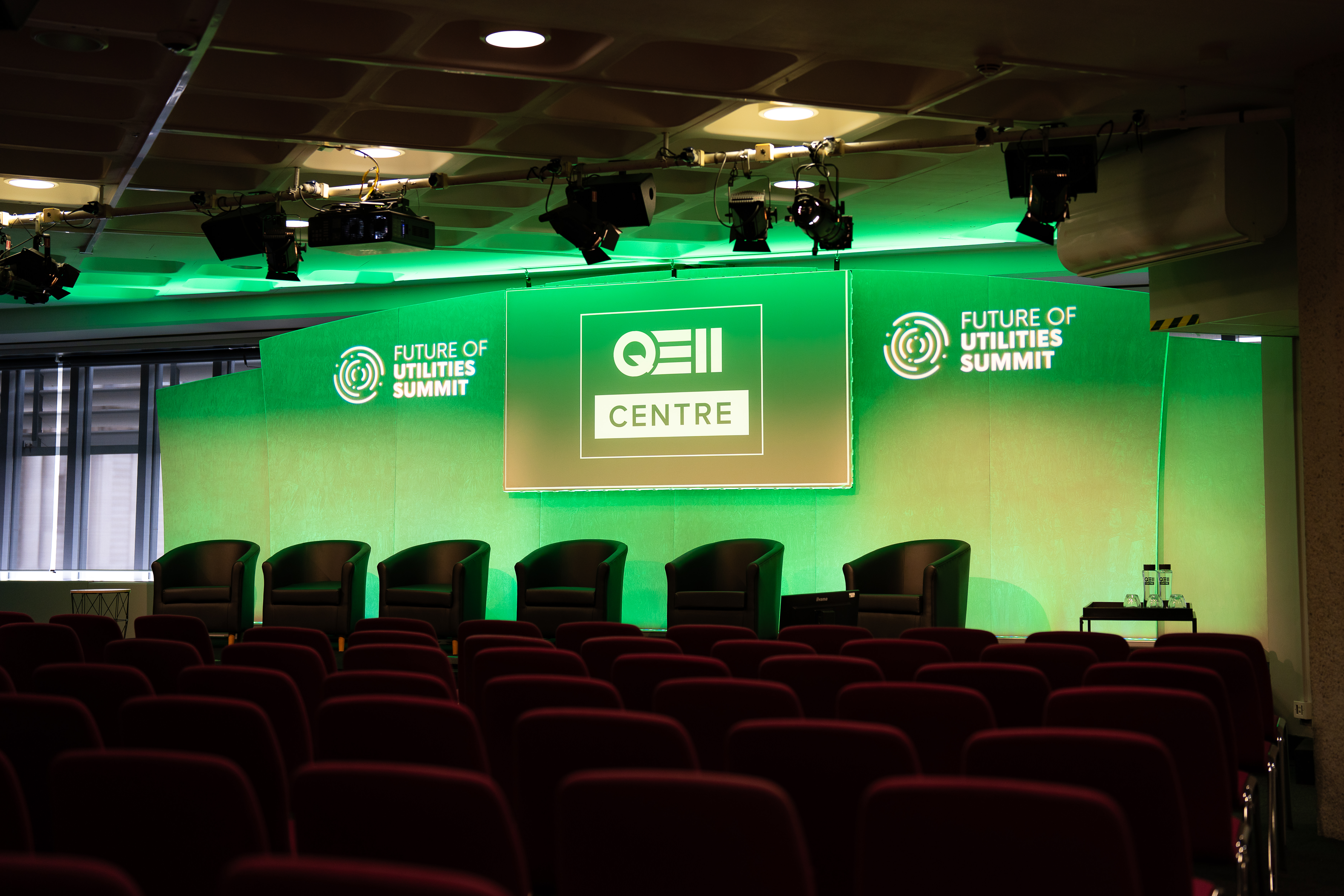 St James conference space at QEII Centre for Future of Utilities Summit, sleek green backdrop.