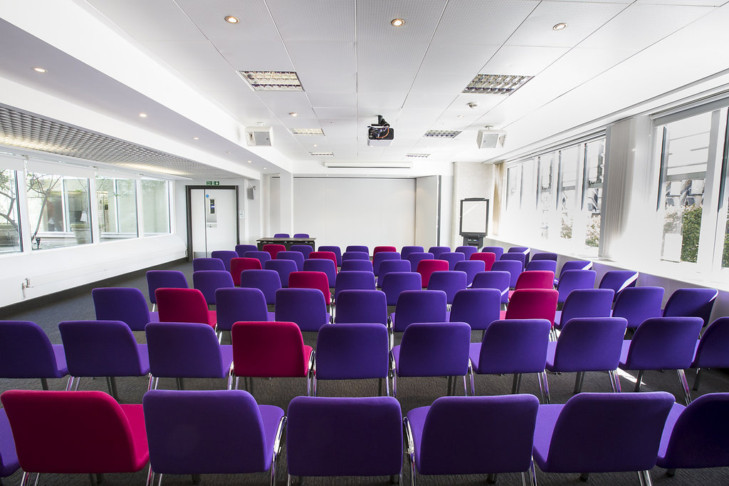 Modern meeting room with purple chairs in QEII Centre, ideal for workshops and presentations.