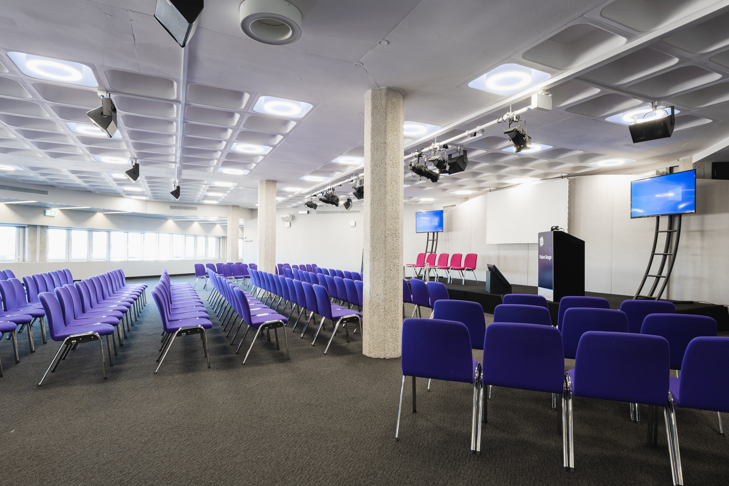 Modern event space in QEII Centre with purple chairs for conferences and presentations.