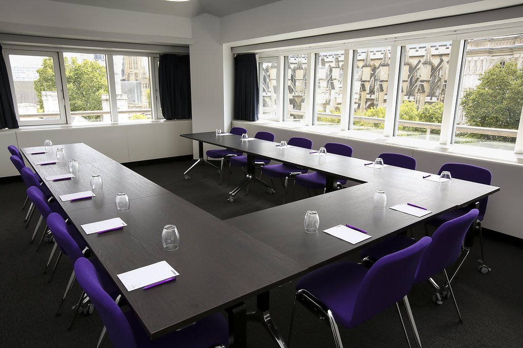 Hawking in a U-shaped meeting room with purple chairs, ideal for workshops and discussions.