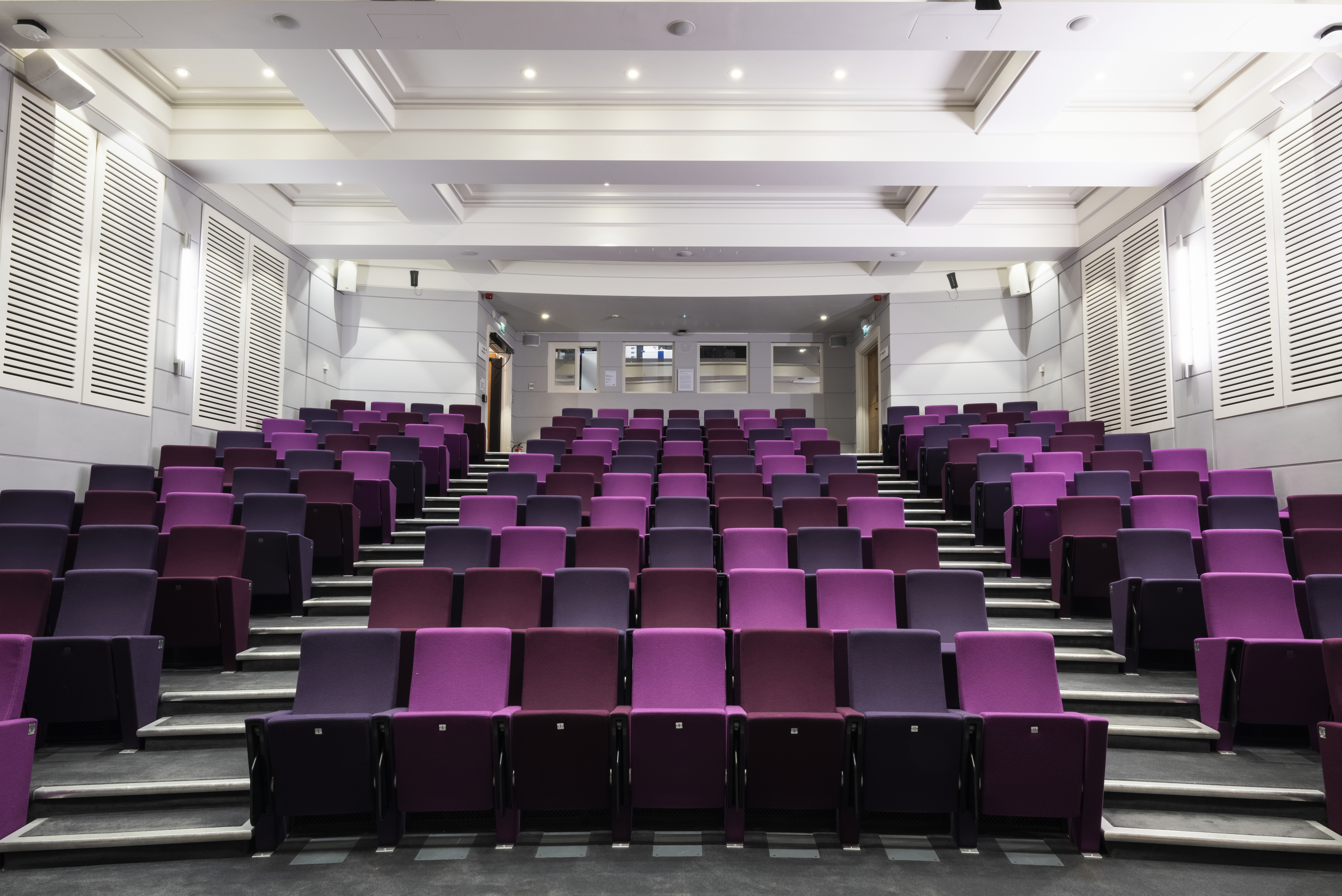 Henry Wellcome Auditorium with tiered purple seating for conferences and presentations.
