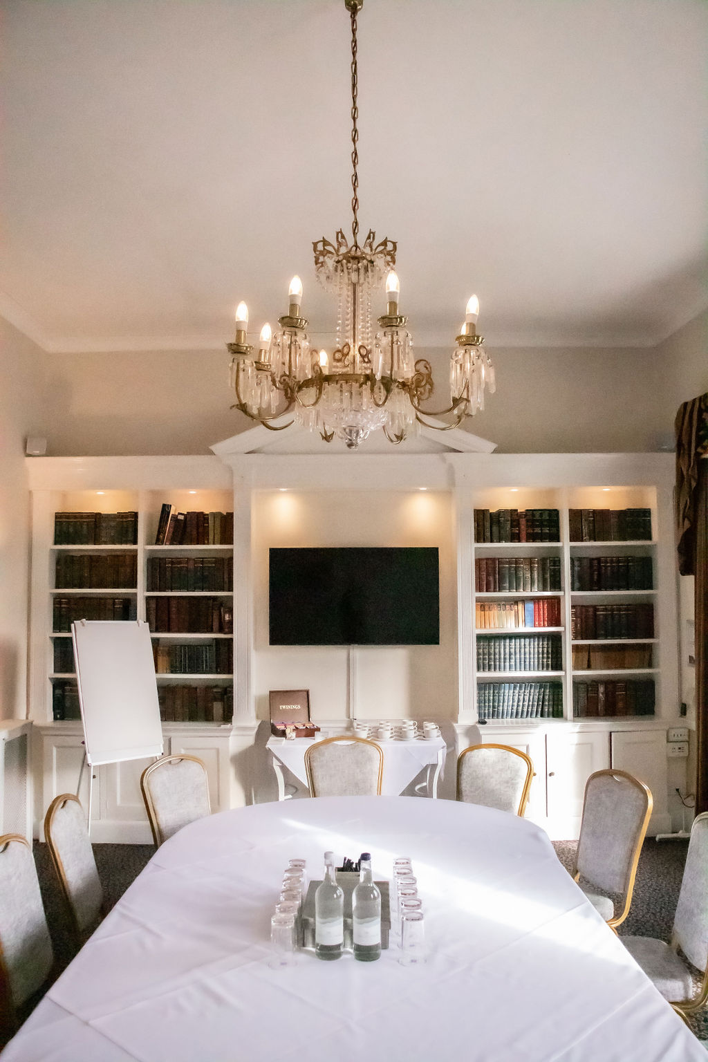 Elegant library meeting room with chandelier at Manor of Groves Hotel for events.