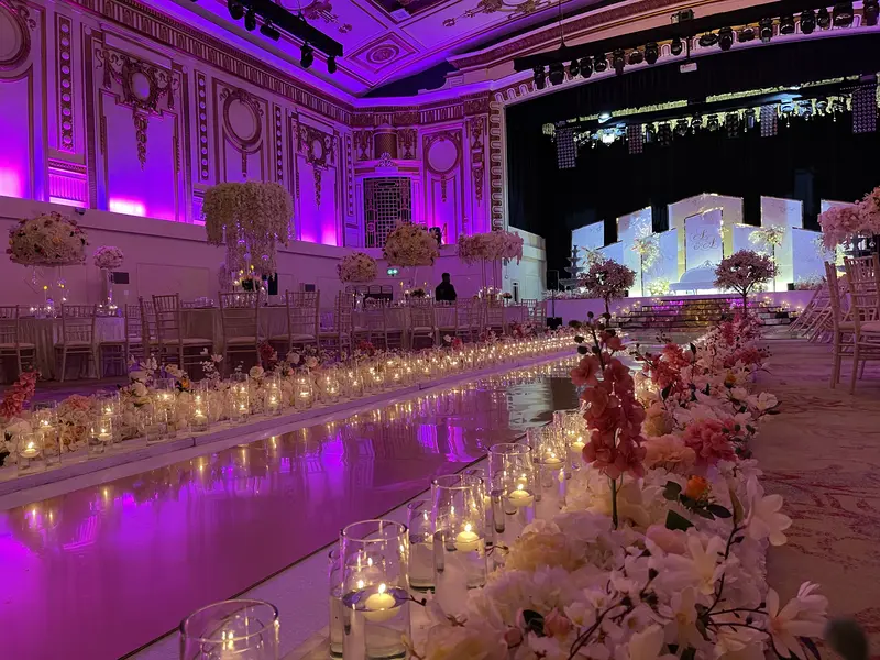 "Elegant Grand Ballroom at The Royal Regency with pink lighting, perfect for weddings or events."