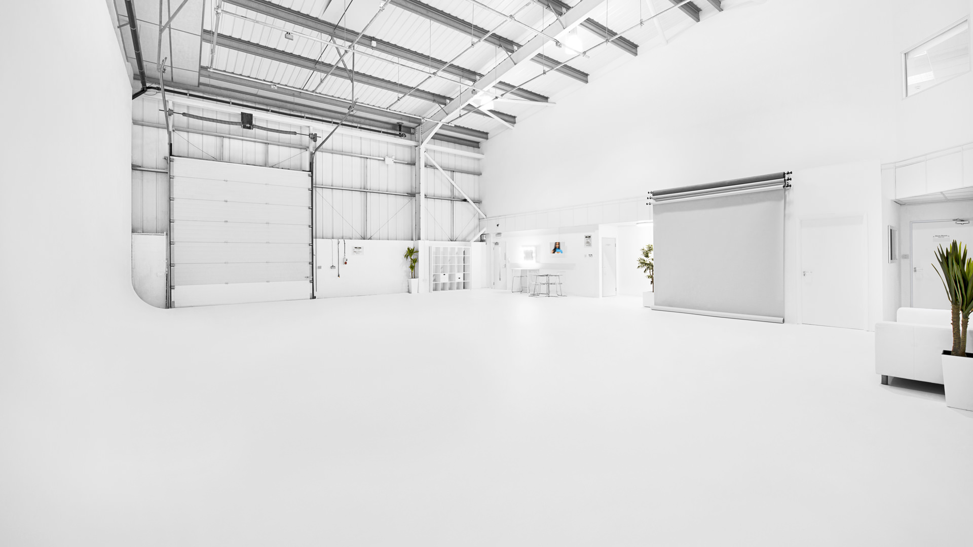 Spacious minimalist event space with high ceilings for corporate meetings and workshops.