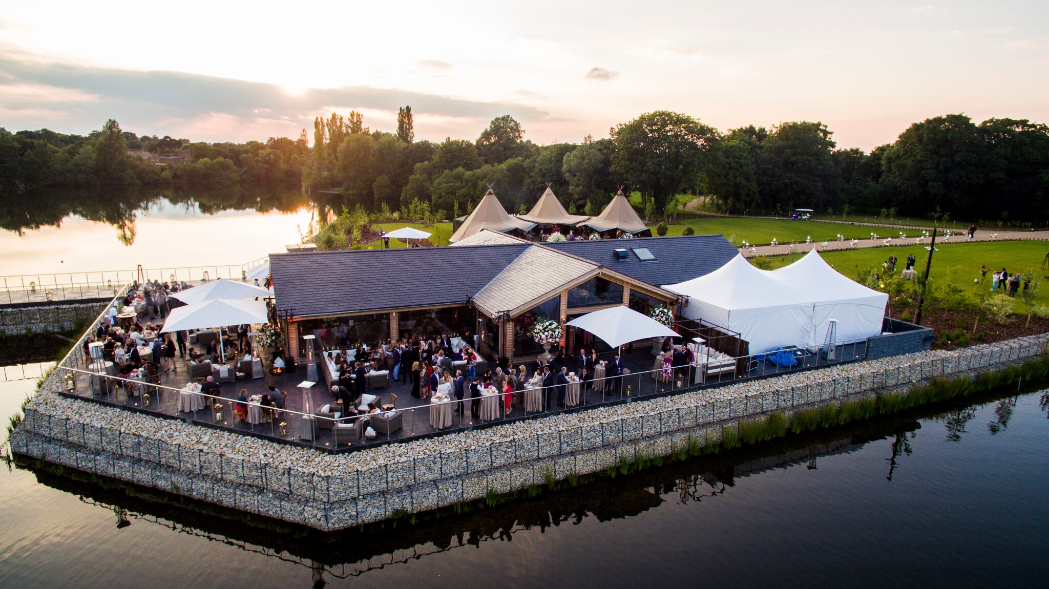 Outdoor event venue at Amber Lakes with elegant tents and serene water view.
