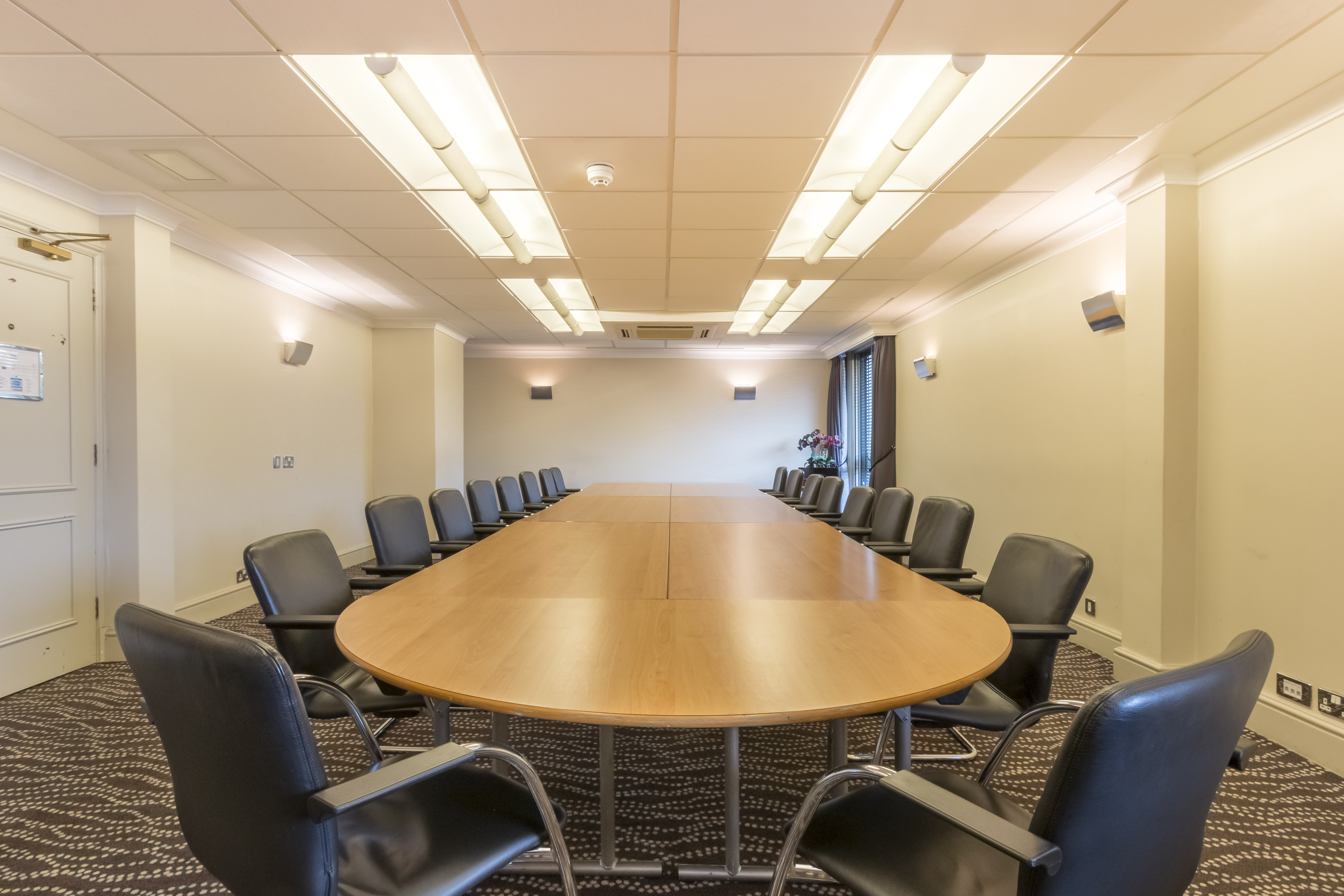 Caravelle Suite at Thistle London Heathrow: modern meeting room with oval table, ideal for workshops.