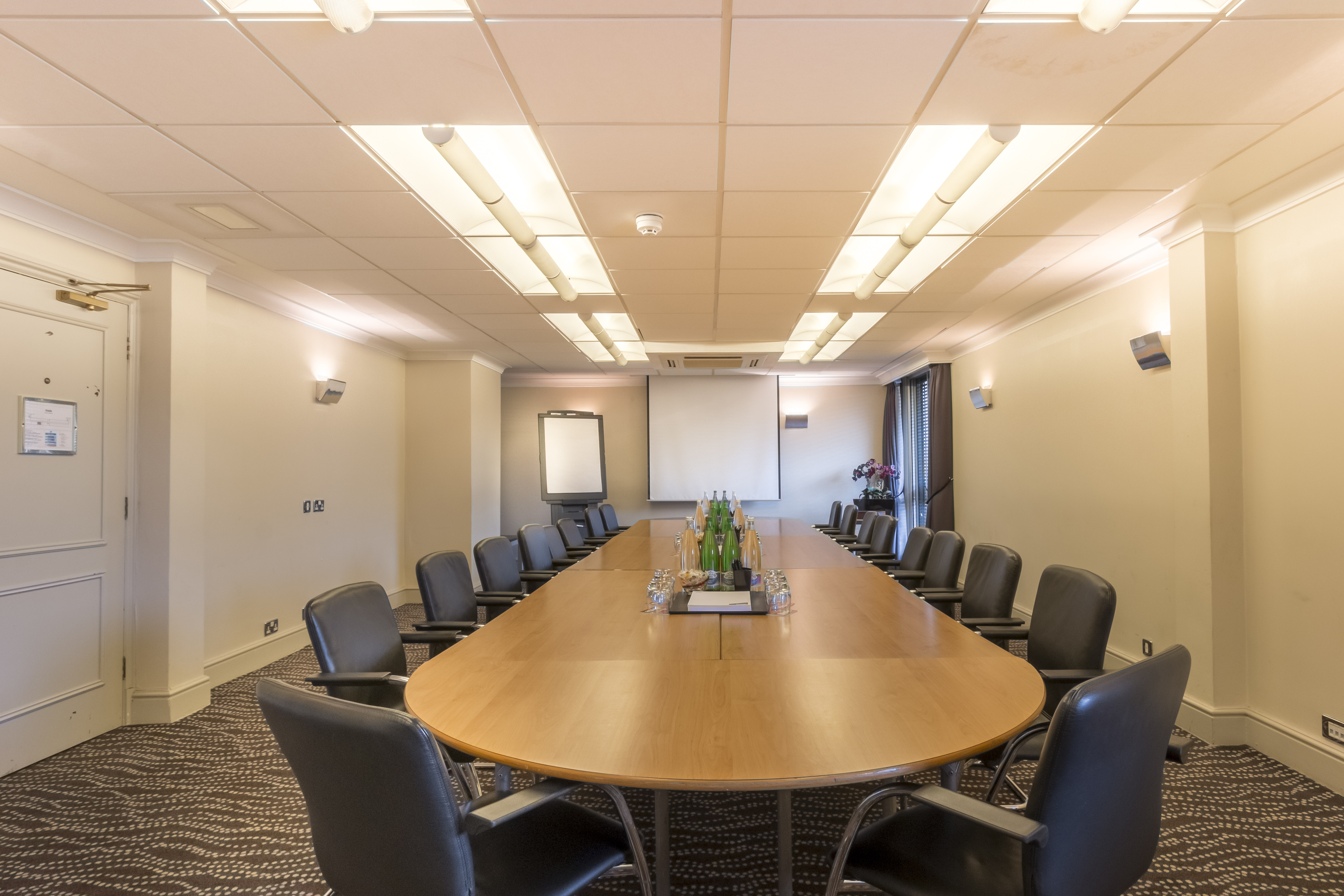 Caravelle Suite meeting room at Thistle London Heathrow, featuring an oval table and whiteboard.