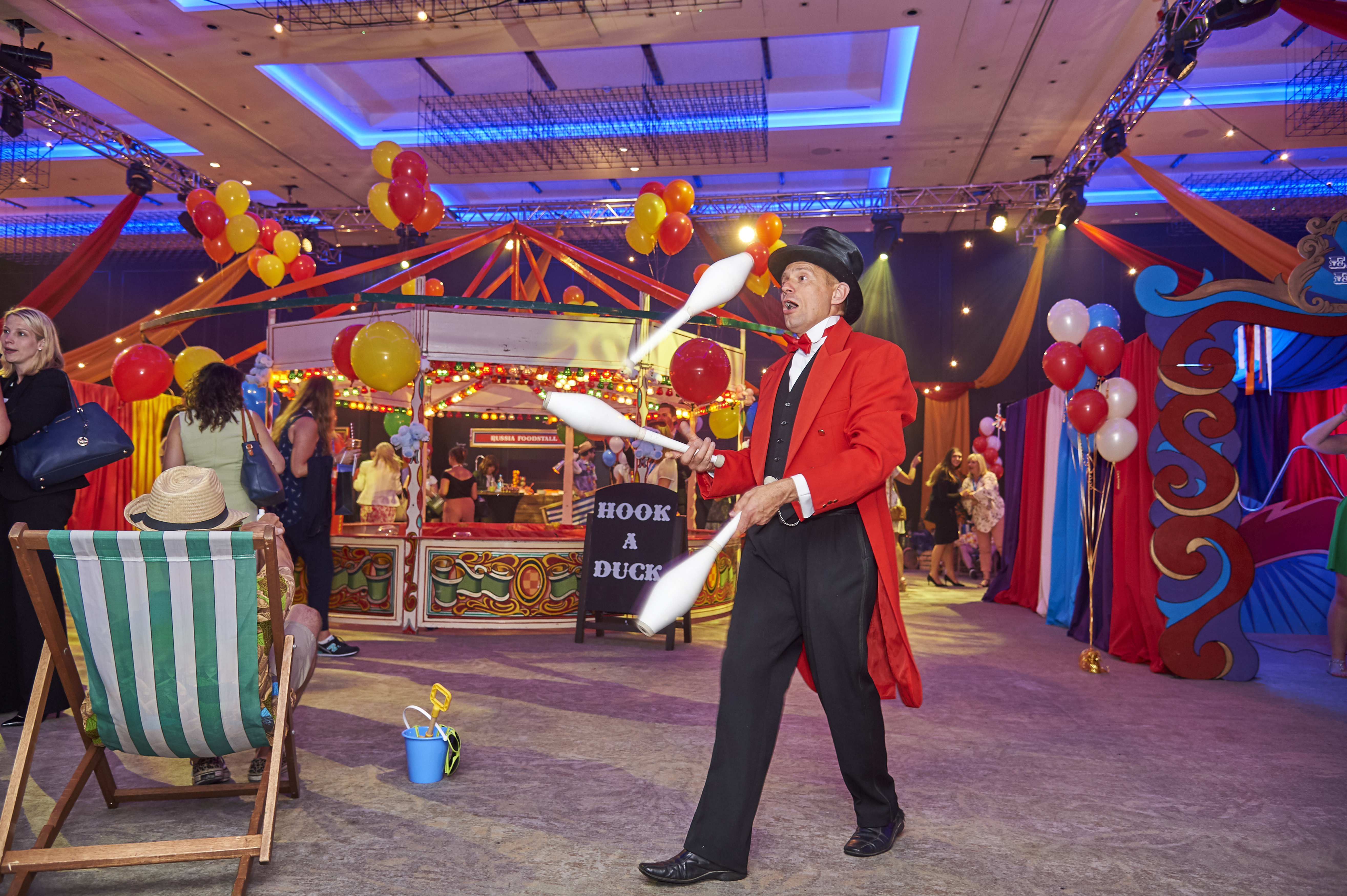 Carnival-themed event at Bankside Ballroom with juggler and colorful decorations.