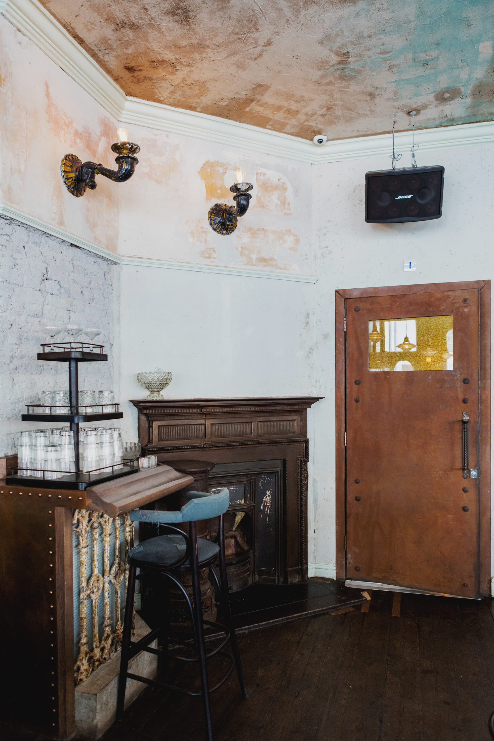 Cozy vintage event space in Martello Hall with exposed brick and elegant wooden door.