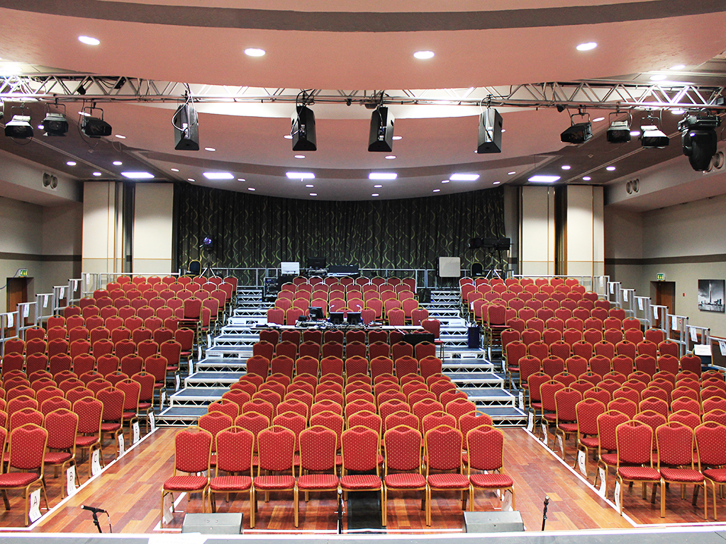 Riverside auditorium with tiered red seating for conferences and performances.