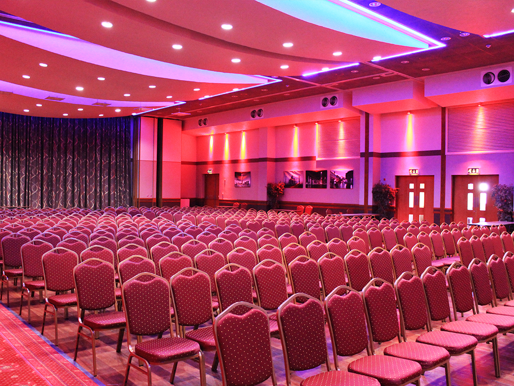 Spacious conference hall at Venue 360 with purple lighting for corporate events.