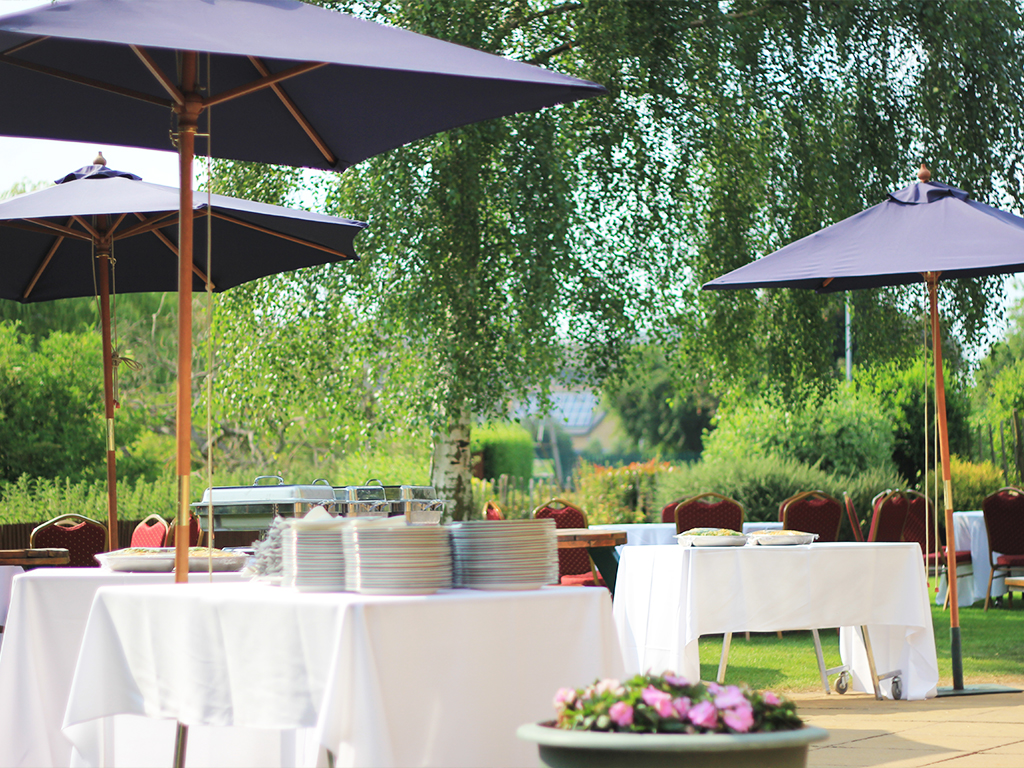 Elegant outdoor event space with lush greenery, perfect for cocktail receptions or garden parties.