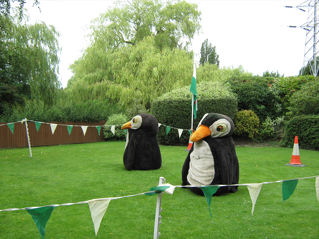 Whimsical outdoor event setup at Venue 360 with oversized penguin mascots.