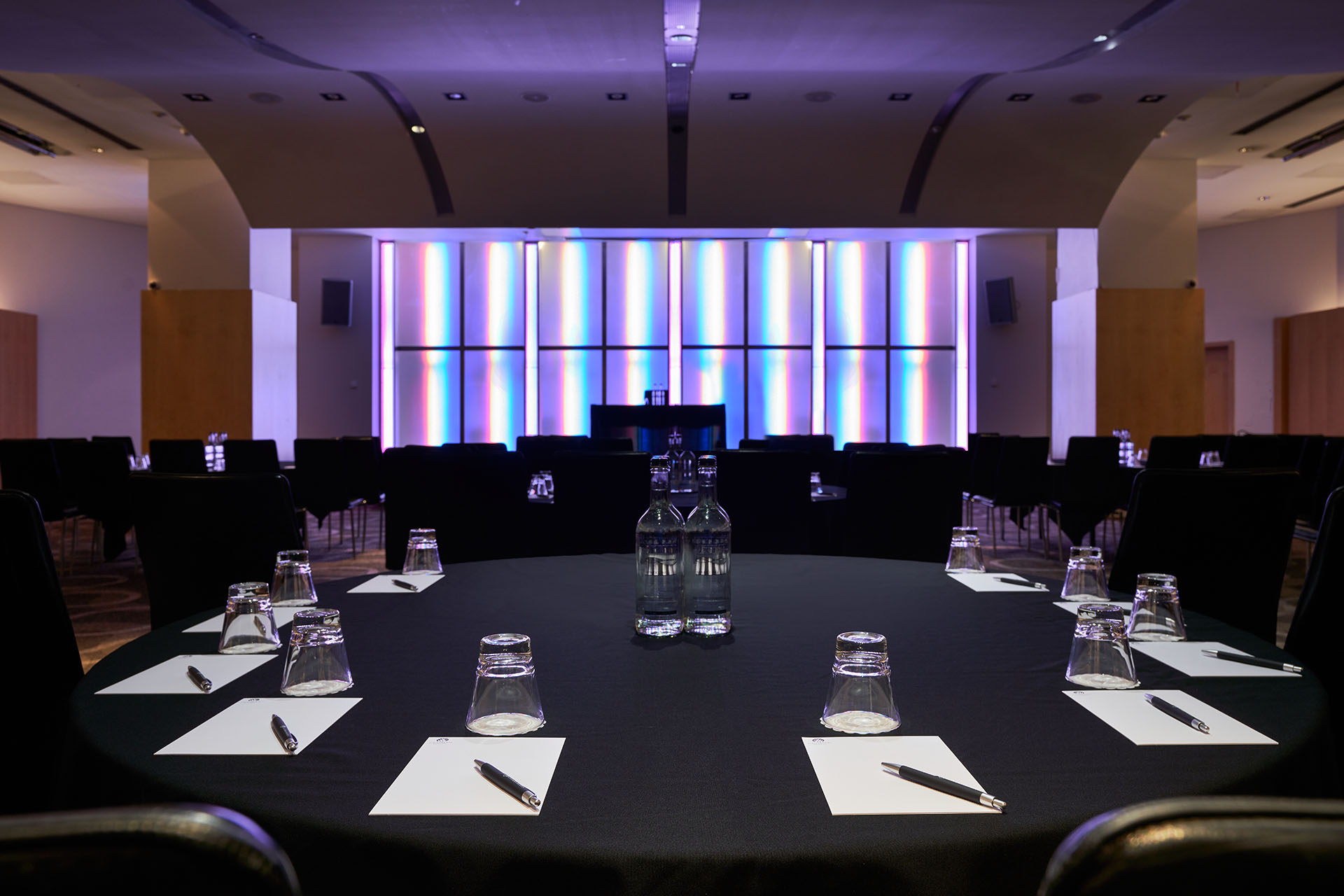 Modern meeting space at The Arena, Cumberland Hotel with round table setup for events.