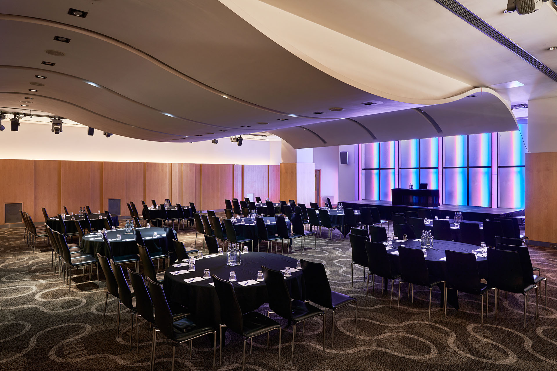 Versatile event space at The Cumberland Hotel with sleek curved ceiling for conferences.